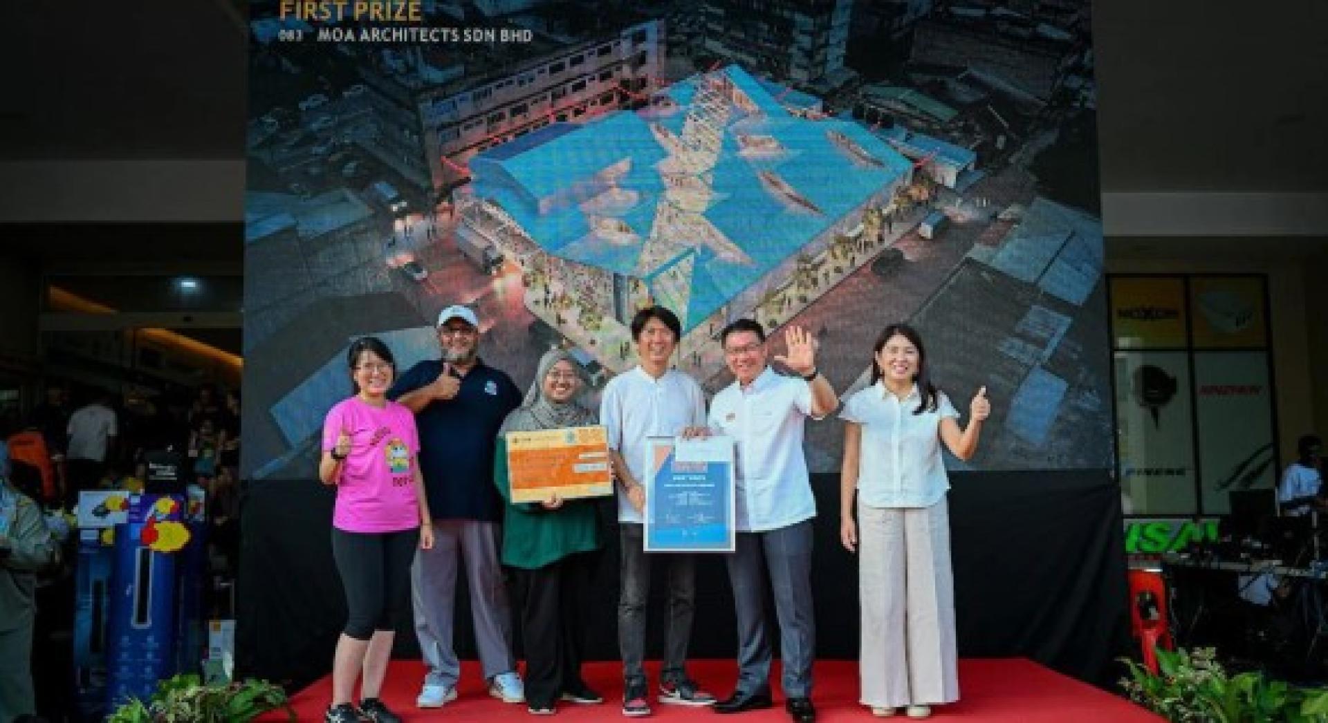 倪可敏（有2起）将5万令吉奖金颁发给沙登新村巴刹公开设计比赛冠军得主MOA Architects Sdn Bhd的代表，其作品将作为重建方案的设计图。右为杨美盈；左为王诗棋。