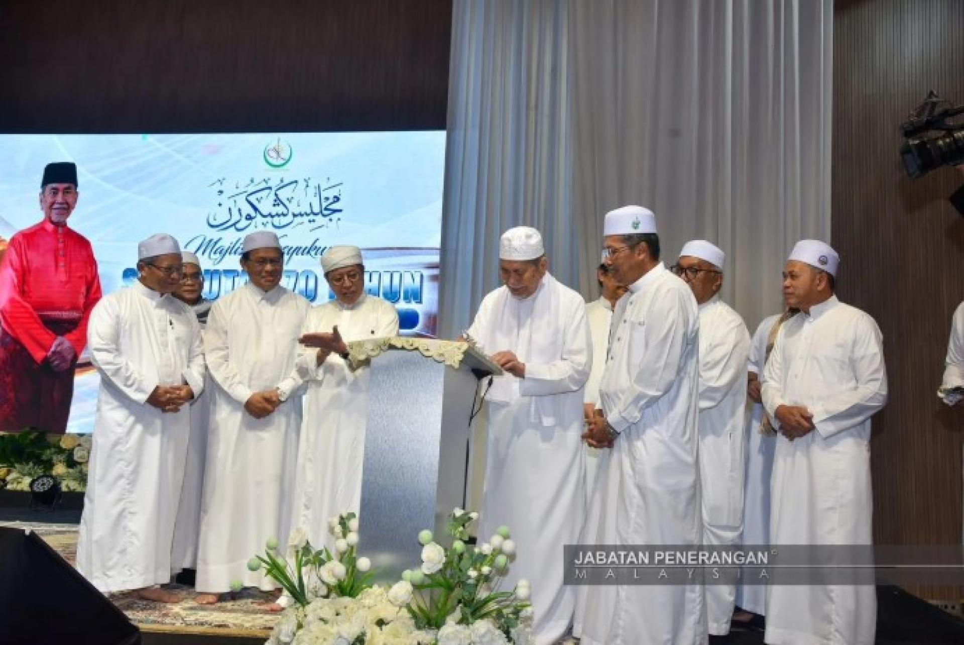 Wan Junaidi menyempurnakan simbolik pelancaran Logo 70 Tahun MIS pada Majlis Kesyukuran Sambutan 70 Tahun MIS di Dewan Kompleks Islam Sarawak.
