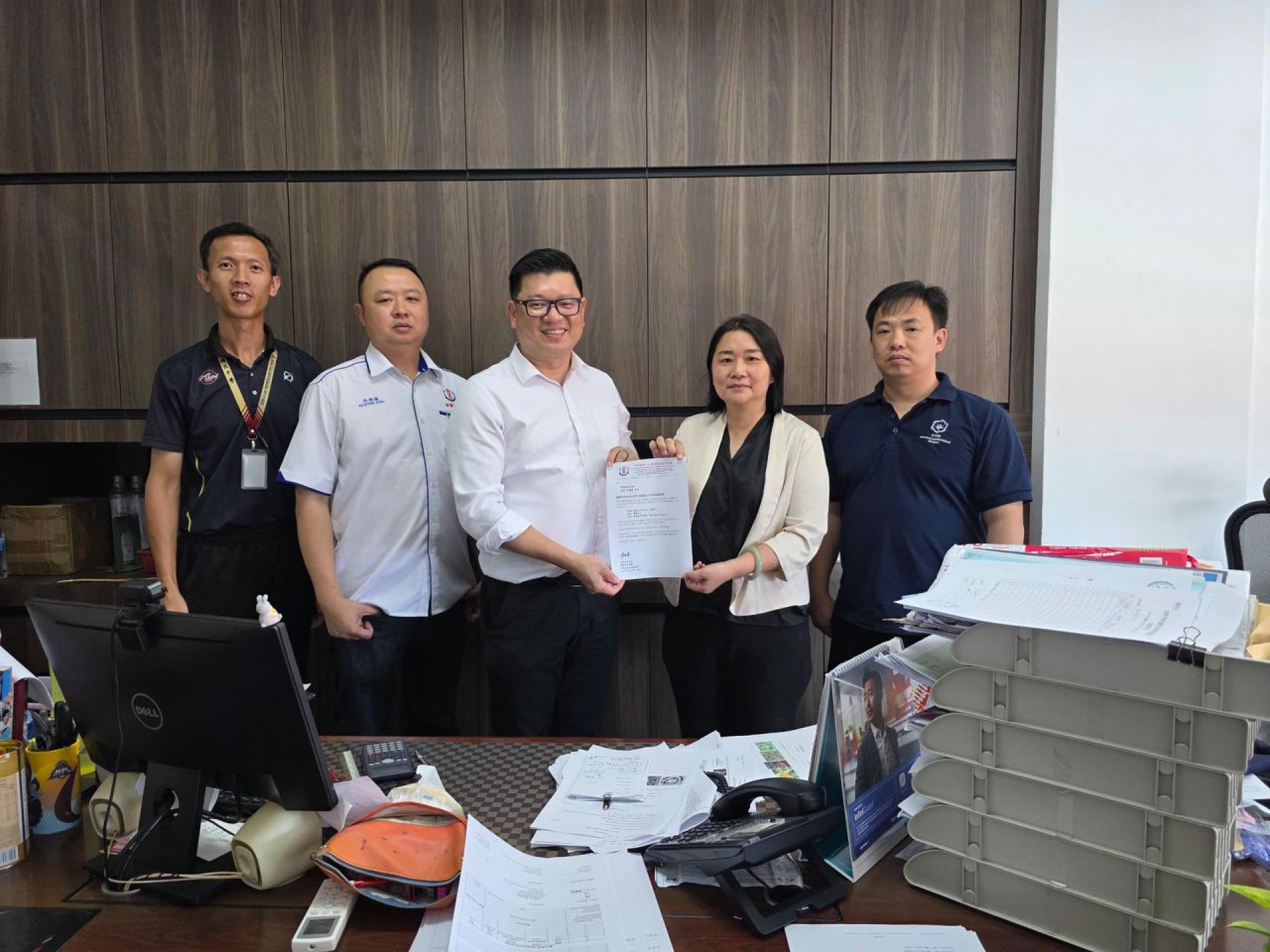 筹备会主席兼砂拉越华总青年团团长范宏祥市议员（左3）移交邀请函于培民中学校长贝美娇（右2）。