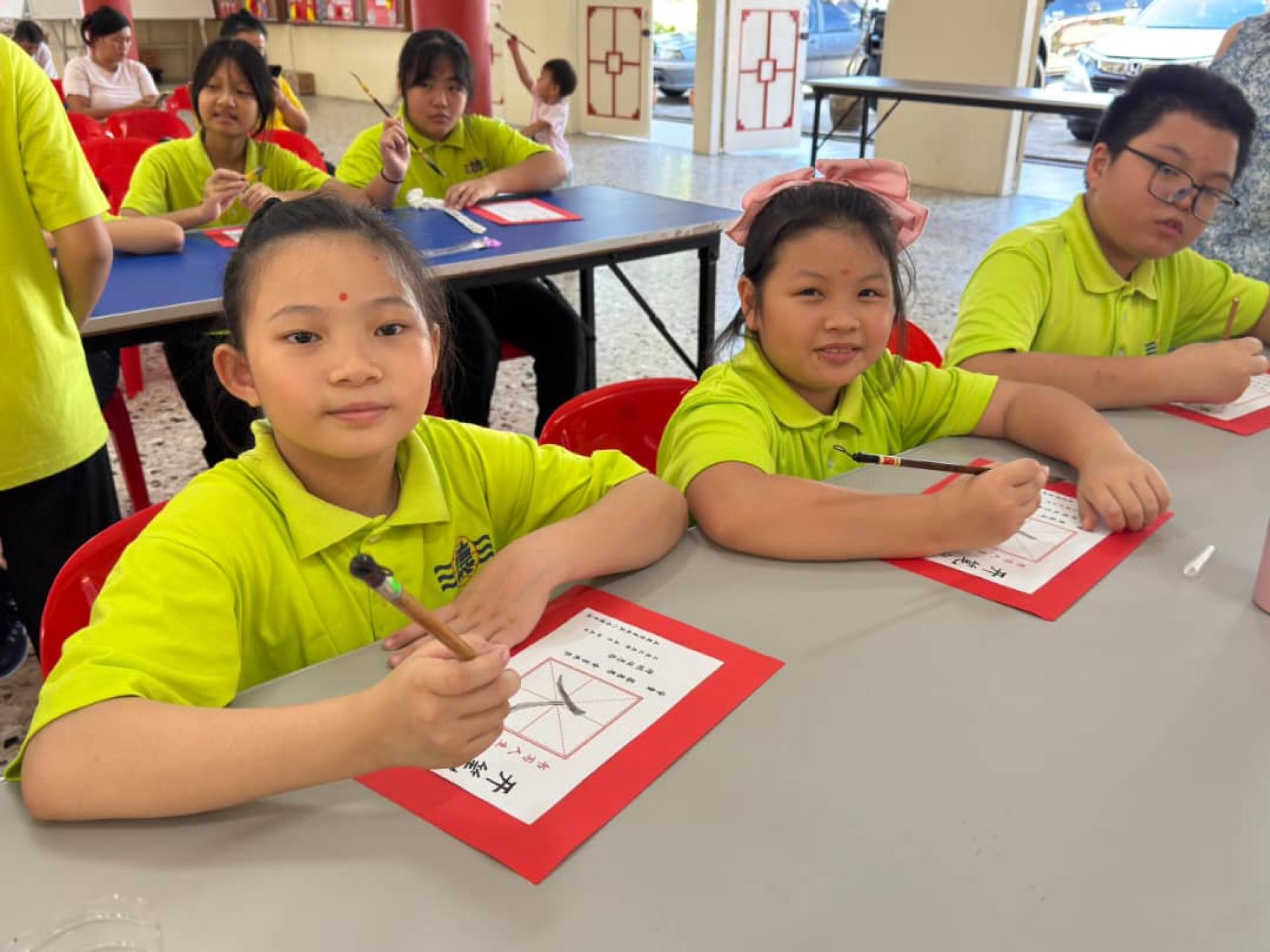 新生们在开笔礼活动上一起描红“人”字，象征人生学习旅程的起点。
