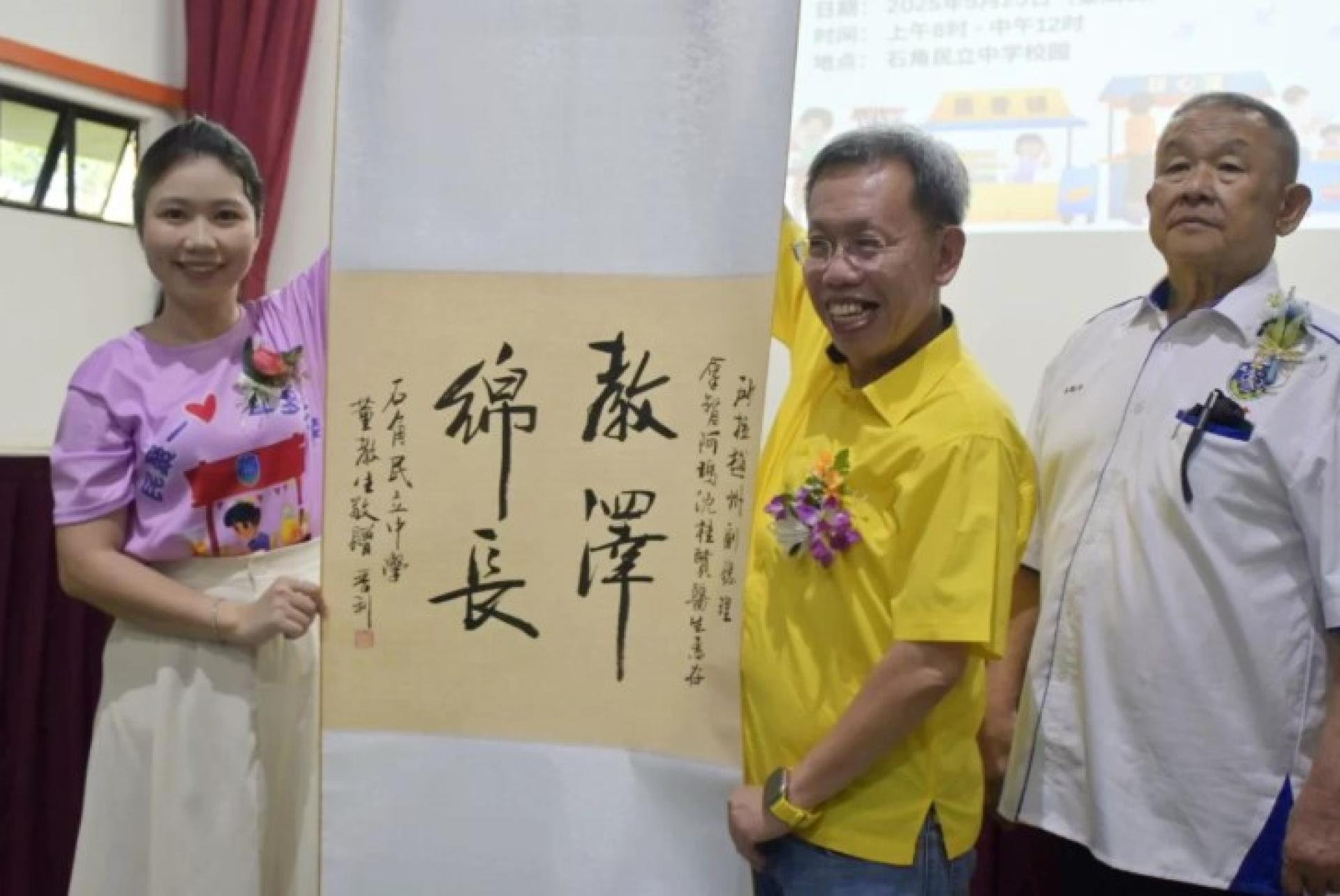 筹款义卖会主席兼校长赖淑珍向嘉宾、砂拉越副总理拿督阿玛沈桂贤赠送书法作品。