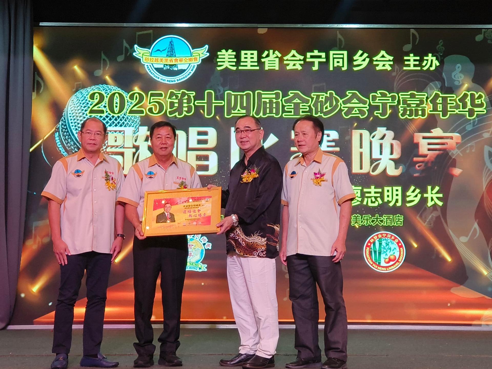 第14届全砂会宁嘉年华华语歌唱比赛筹备会主席黄桠桔（左2）赠送纪念品给马来西亚会宁总会会长拿督廖志明（右2）。左为总筹备会主席江先柱，右为美里会宁同乡会会长张志明。