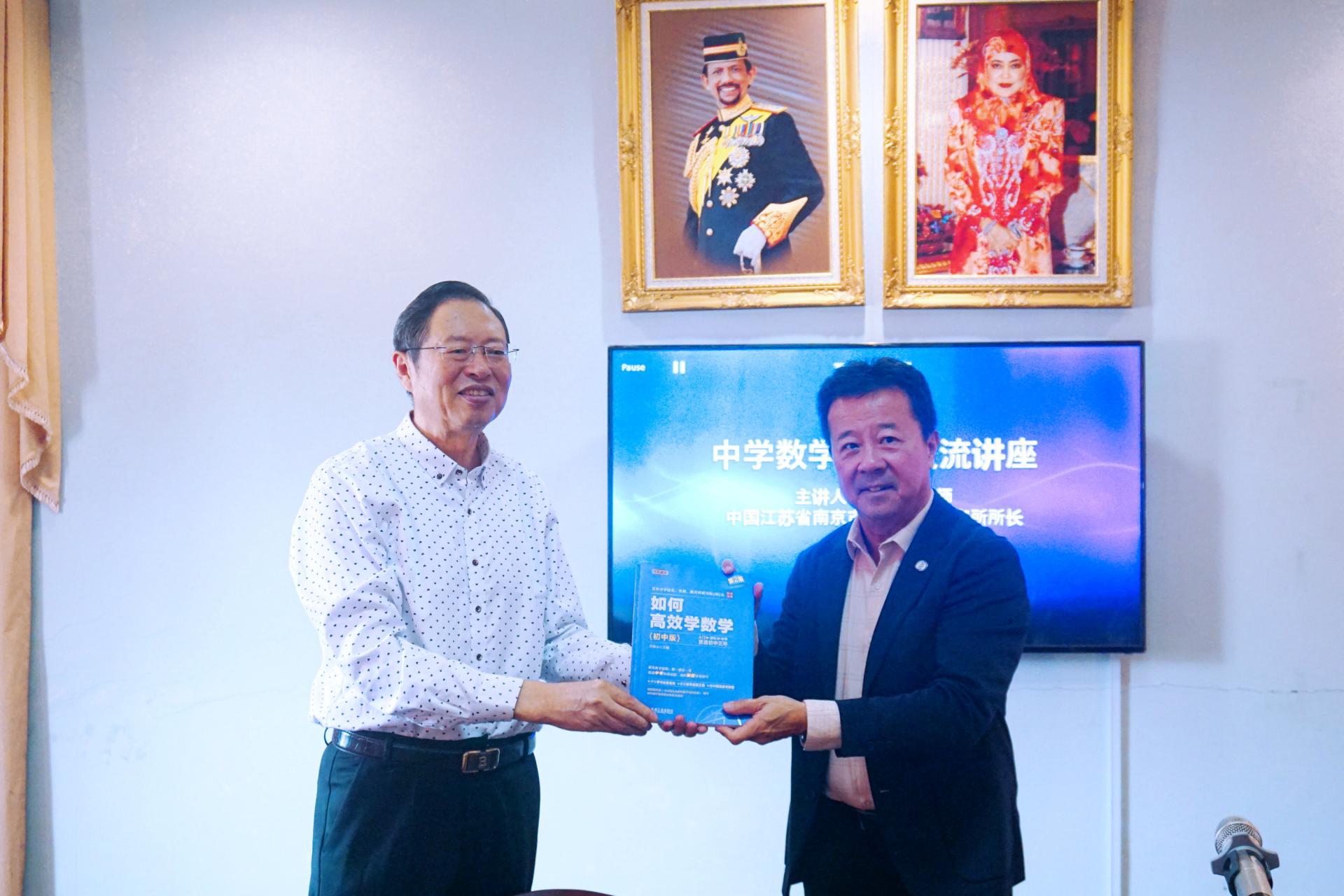 汶中董事长杨德振（右）赠送纪念品予南京教育科学研究所肖林元所长。