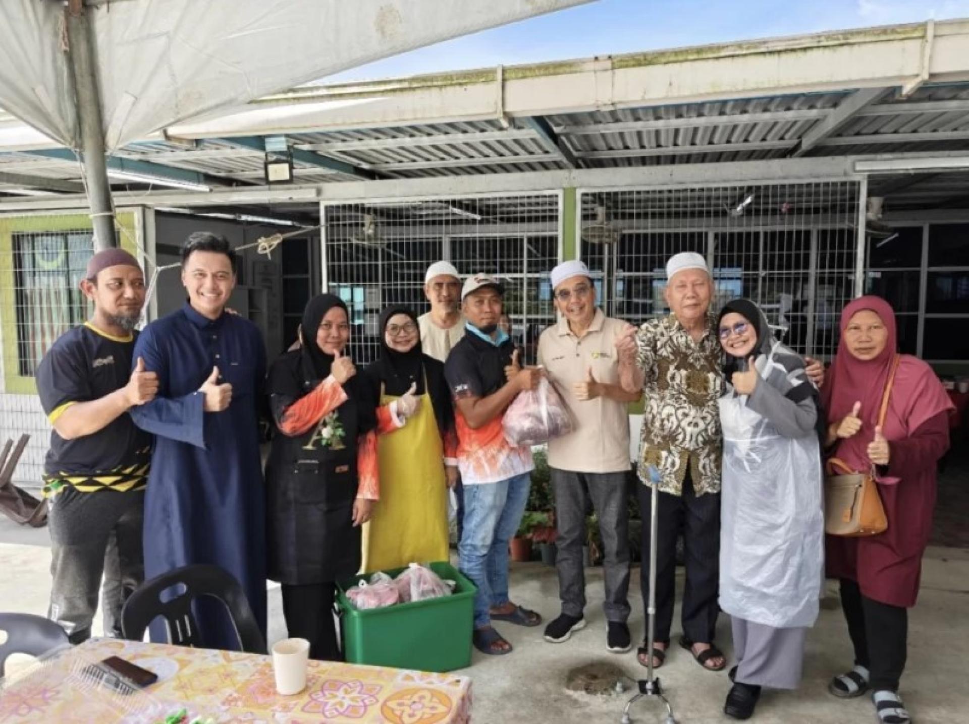 杰夫里（右4）与甘榜布基库迪村委员会成员一起向当地社区分发“qurban”肉品。