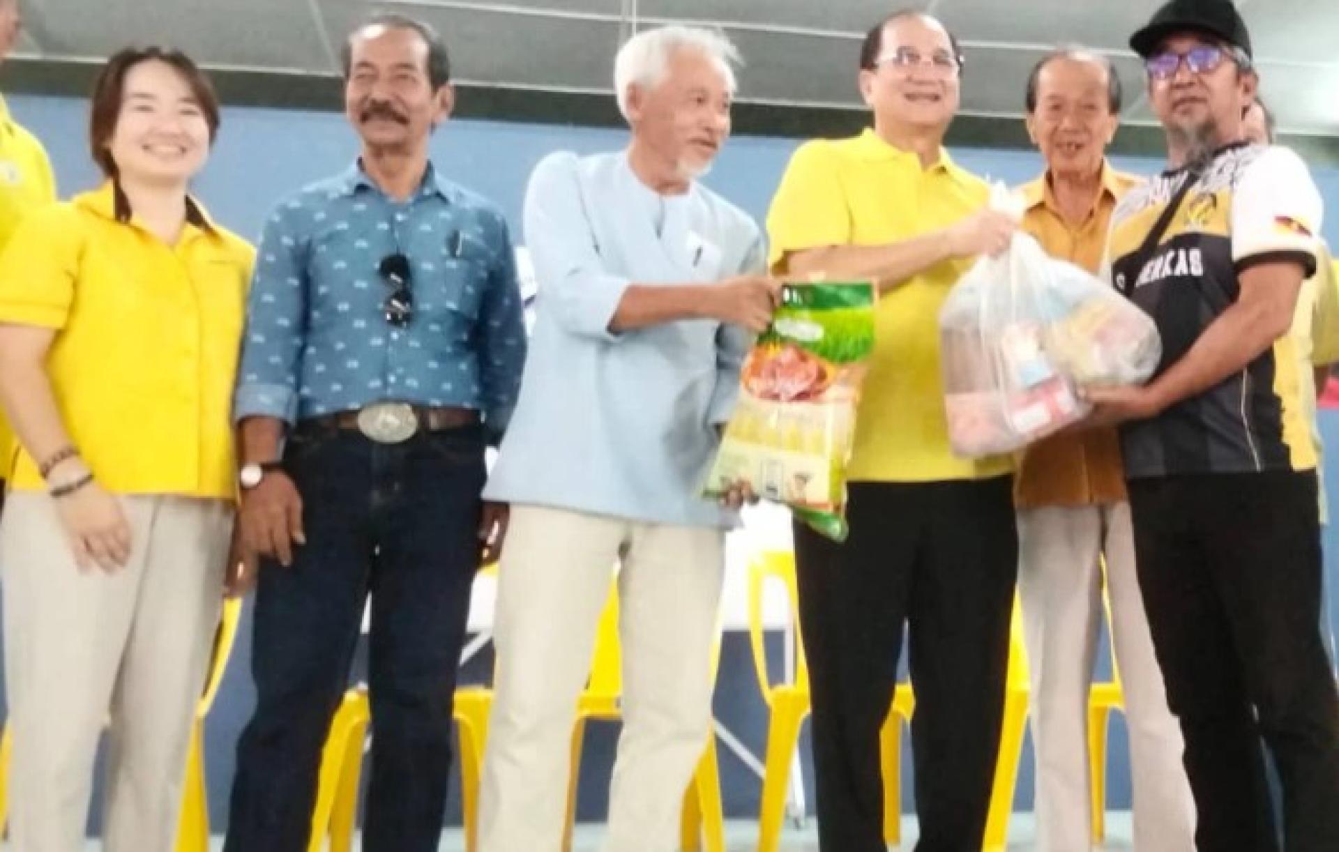 潘隆铭向一名受惠者递交食品篮。
