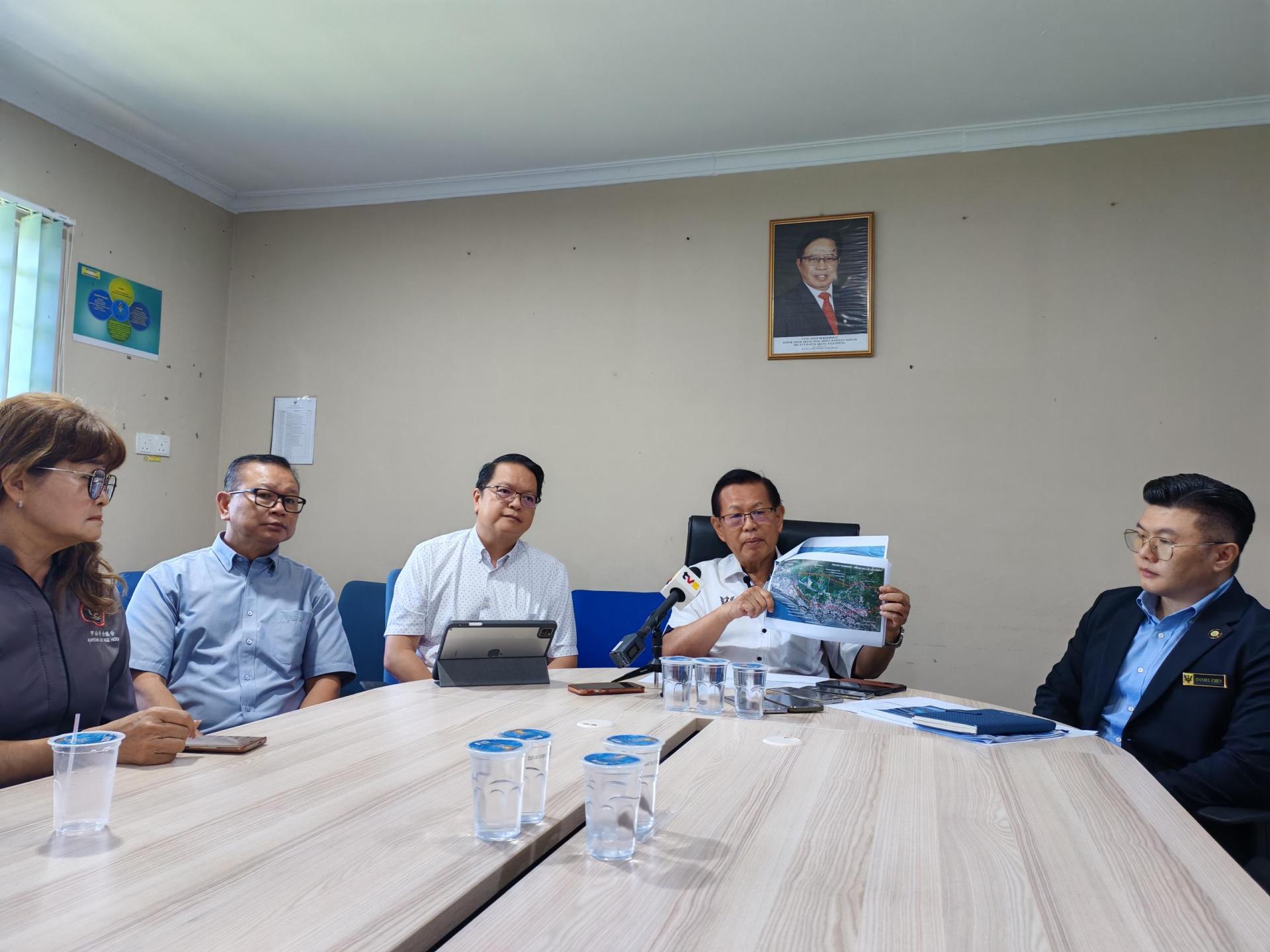 拿督斯里李景胜（右2）展示防洪计划工程蓝图。右1为新任美里水利灌溉局主管工程师曾俊运。左1起为甲必丹余继香、沈清忠市议员和前市议员彭小菶。