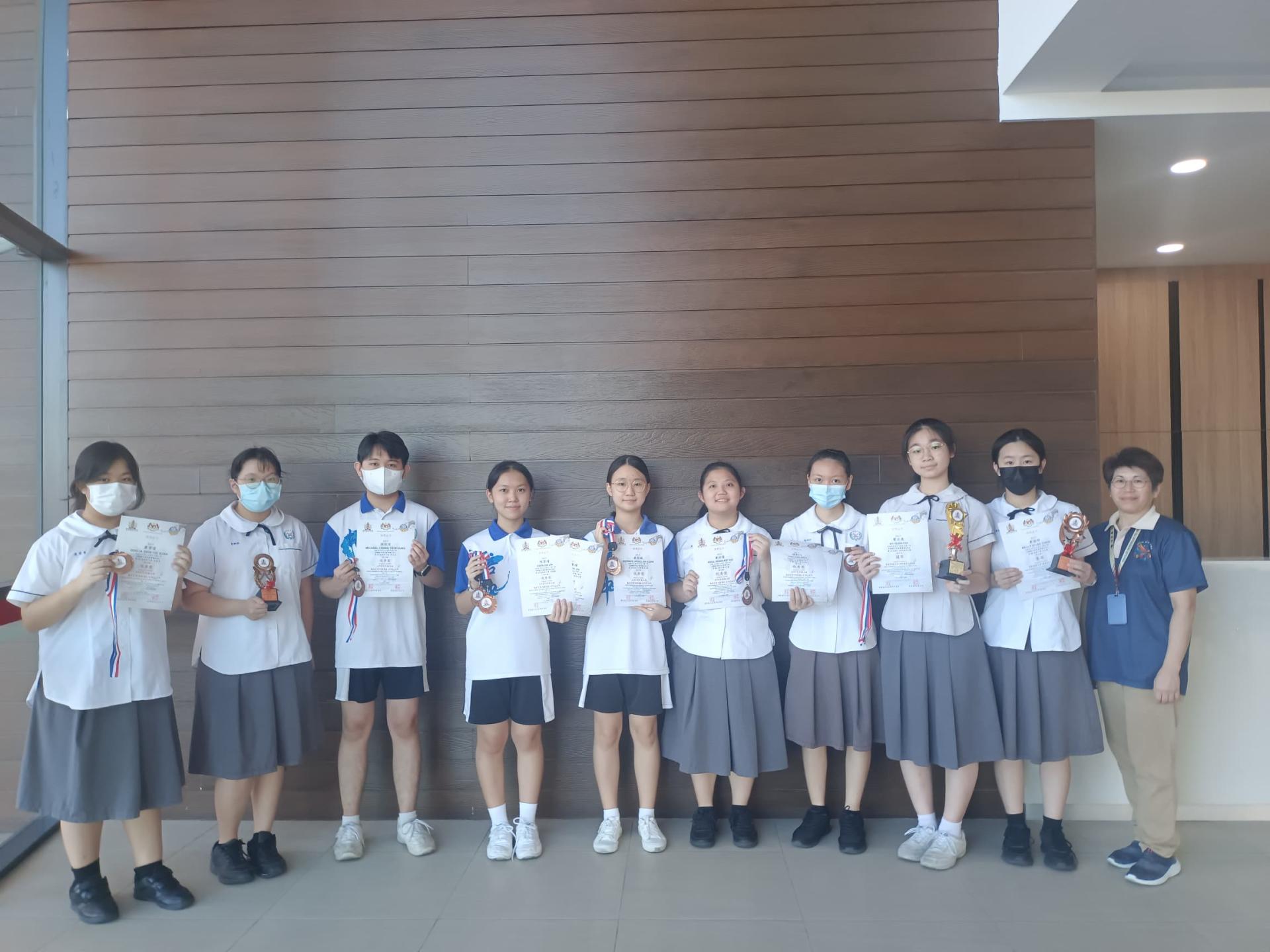 在马潮联青全国学艺美里区域赛夺奖的部分培中生与杨润玲老师（右）合影。