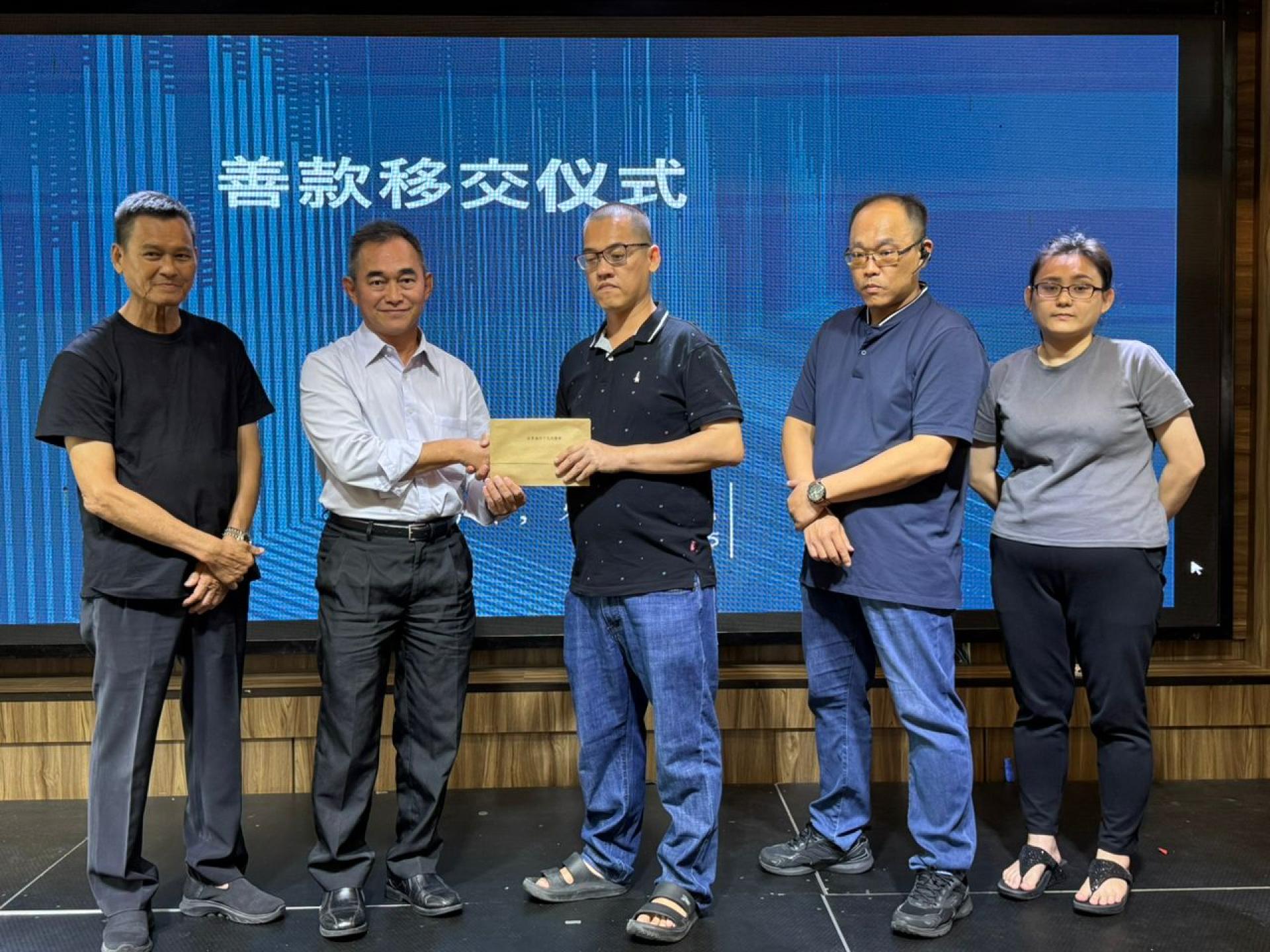 汶莱福州十邑同乡会秘书长刘坤璋（左二）代表从黄钟龙手中接收捐款。左起为拿督黄勤如、黄钟龙，黄钟山，黄钟佩兄妹。