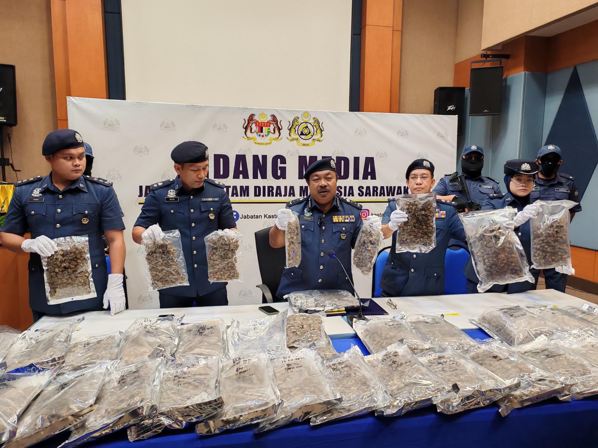 砂拉越关税局总监哈芝诺里赞宾雅雅（左3）向媒体展示截获的大麻花。右2为美里关税局局长沙加丹宾哈芝利曼、马兹迪执法官员（左2）以及其他官员合影于新闻发布会。