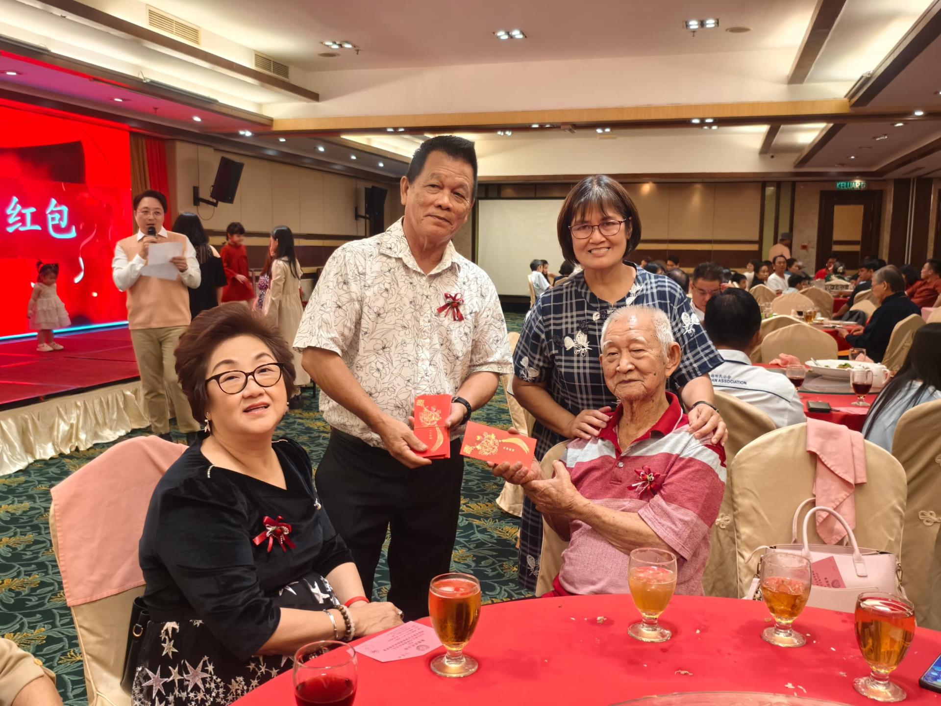 筹备会主席田秀眉（右）陪同美里田氏公会主席田国强（左）分发敬老红包。