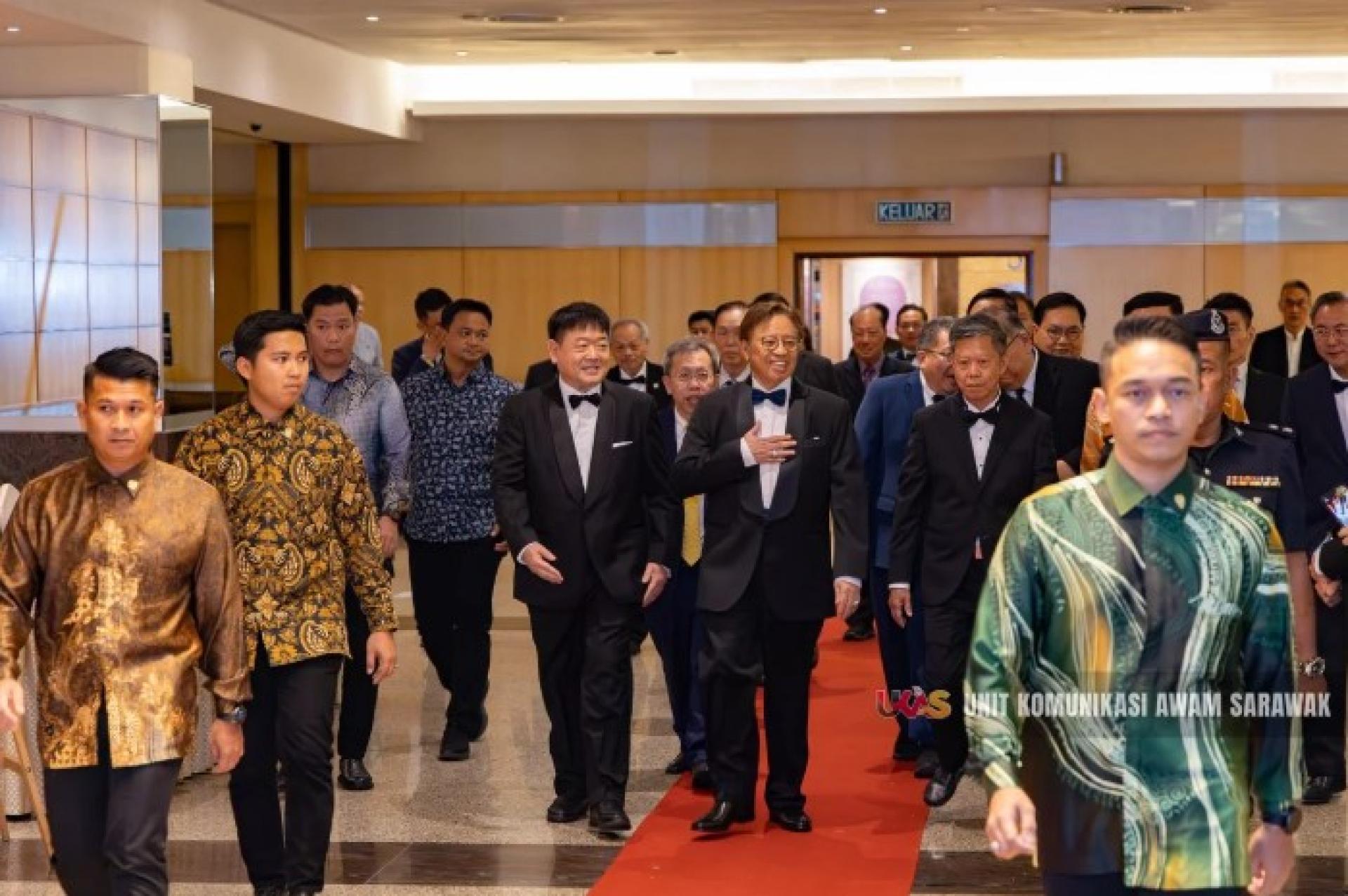 江昌文（左）昨晚在古晋帝国酒店举行的砂中总成立60周年晚宴上迎接阿邦佐哈里的到来。