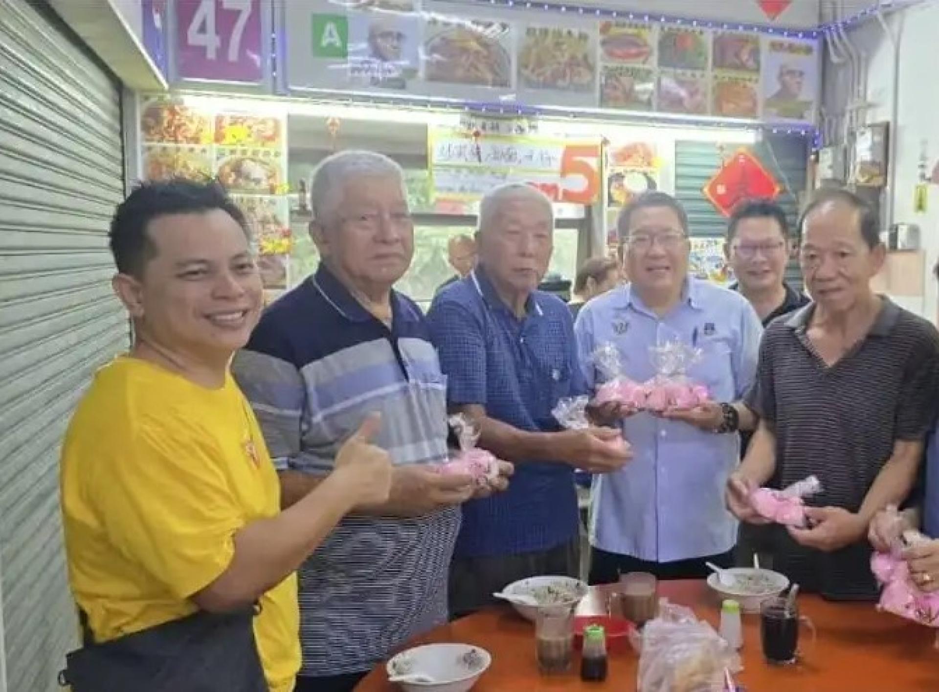 黄鸿圣（左4）于2025年6月15日派发寿桃时的情景。