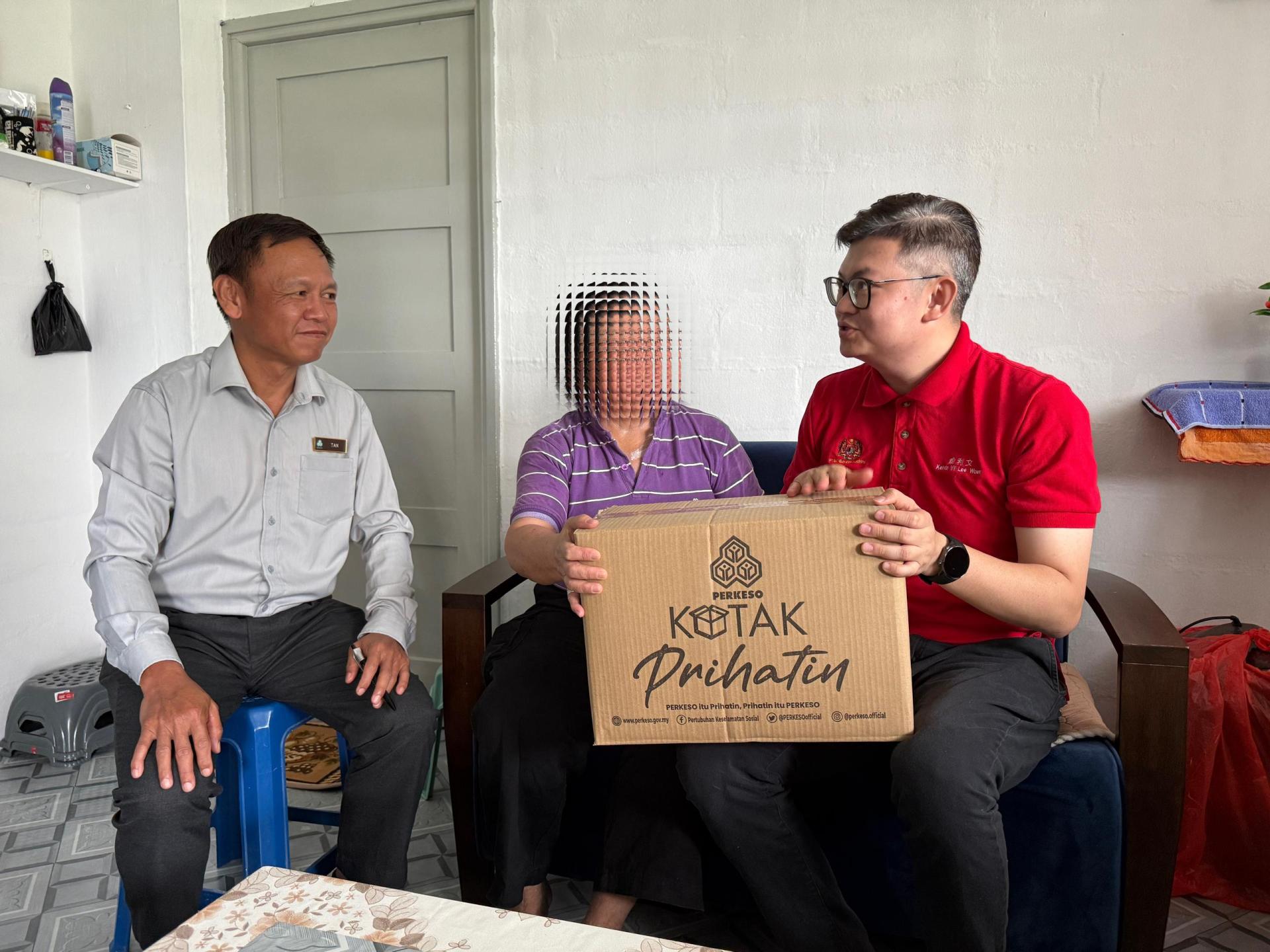 古晋市国会议员俞利文（右1）和社险机构（PERKESO）砂局长陈邦正（左1）移交社险的Prihatin礼盒予已故沈先生的遗孀一瞥。