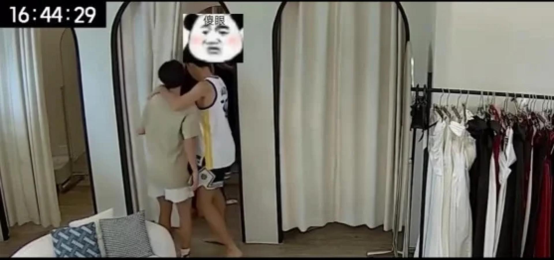 2男拉开试衣间布帘，却发现有人，吓得马上转身离开。