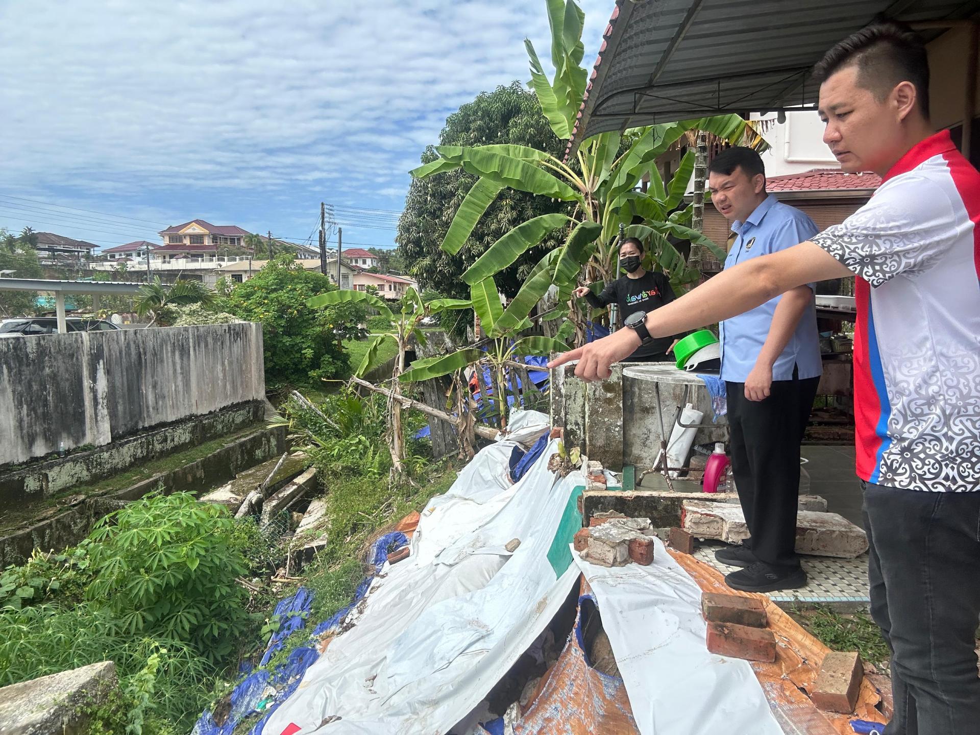 右起为砂民主行动党秘书林思健与美里国会议员赵俊文日前亲自到现场巡视山顶花园3A路附近的一所房屋，该房屋在今年早些时候的洪水中遭到严重破坏。