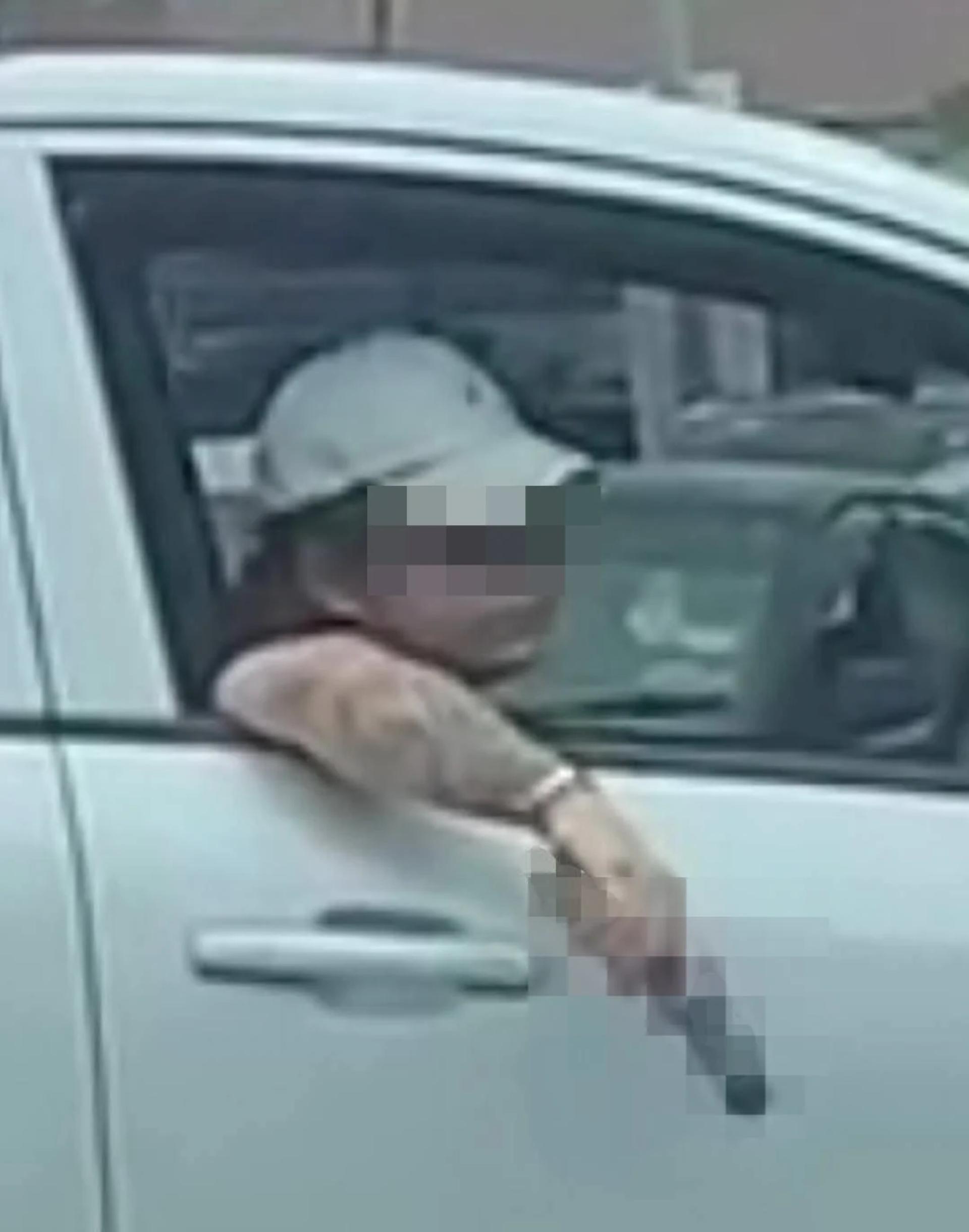 男子边开车，手上持着假枪，架在车门上，被民众把过程拍摄下来。