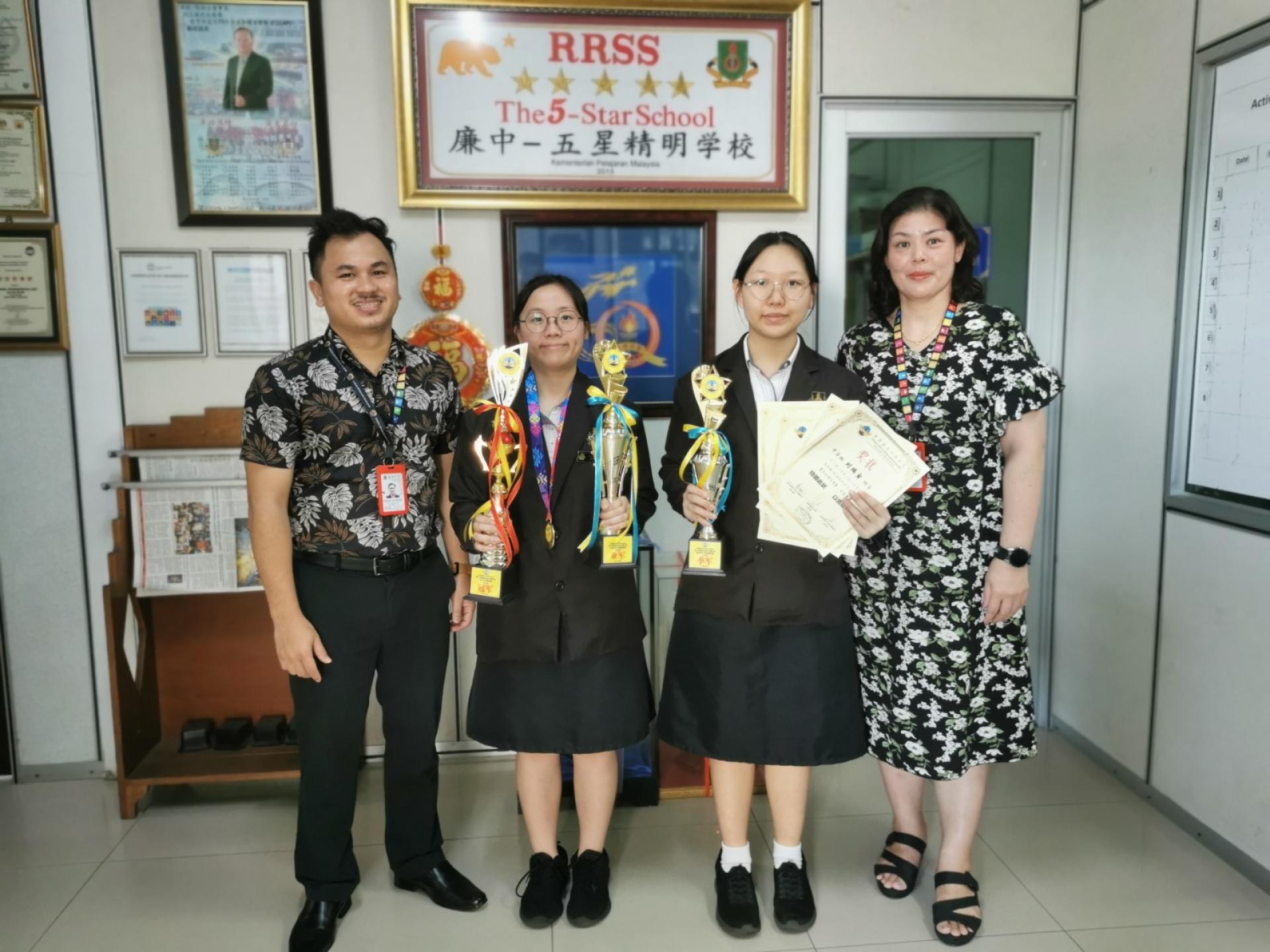 右起为校长江佩娟、刘瑞萱同学、毛甜洋同学与副校长康亚雄合影留念，勉励学生再接再厉，持续追求卓越。