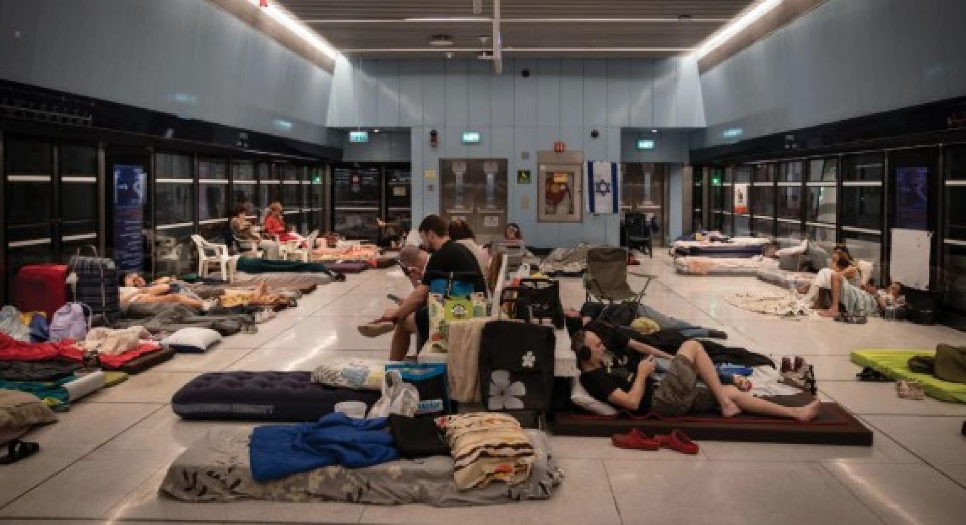 人们20日在以色列特拉维夫一处较深的地铁站过夜。