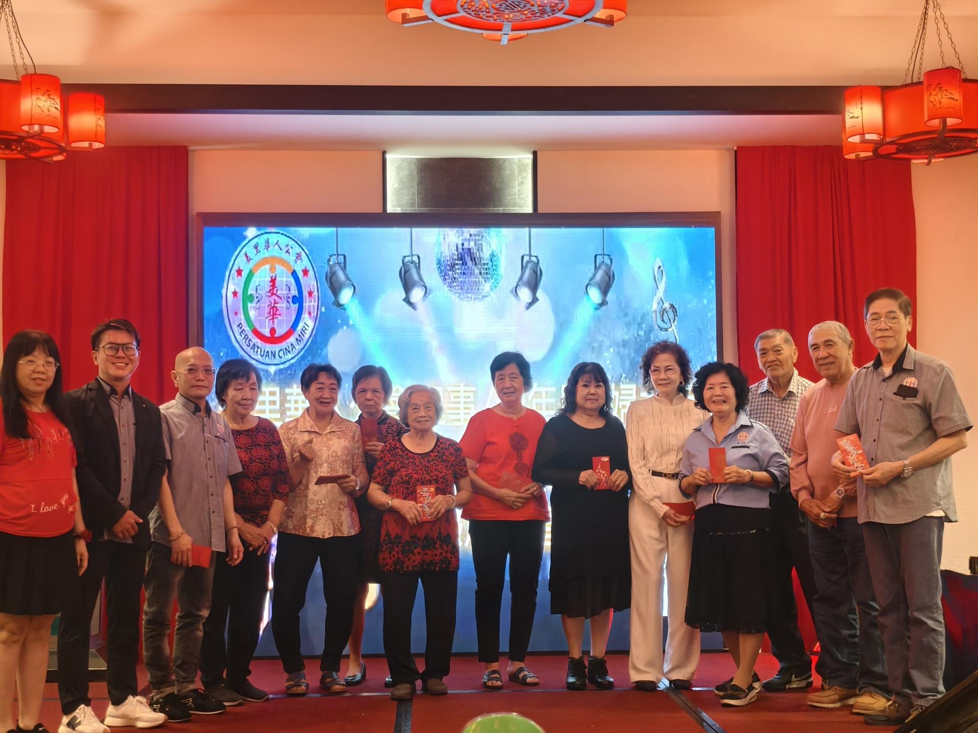 左起为妇女组主任詹有珊、筹备会主席兼秘书长朱景祥、会长张昌盛，颁发乐龄红包给年长会员合影。左7为最年长85岁的郑月香。
