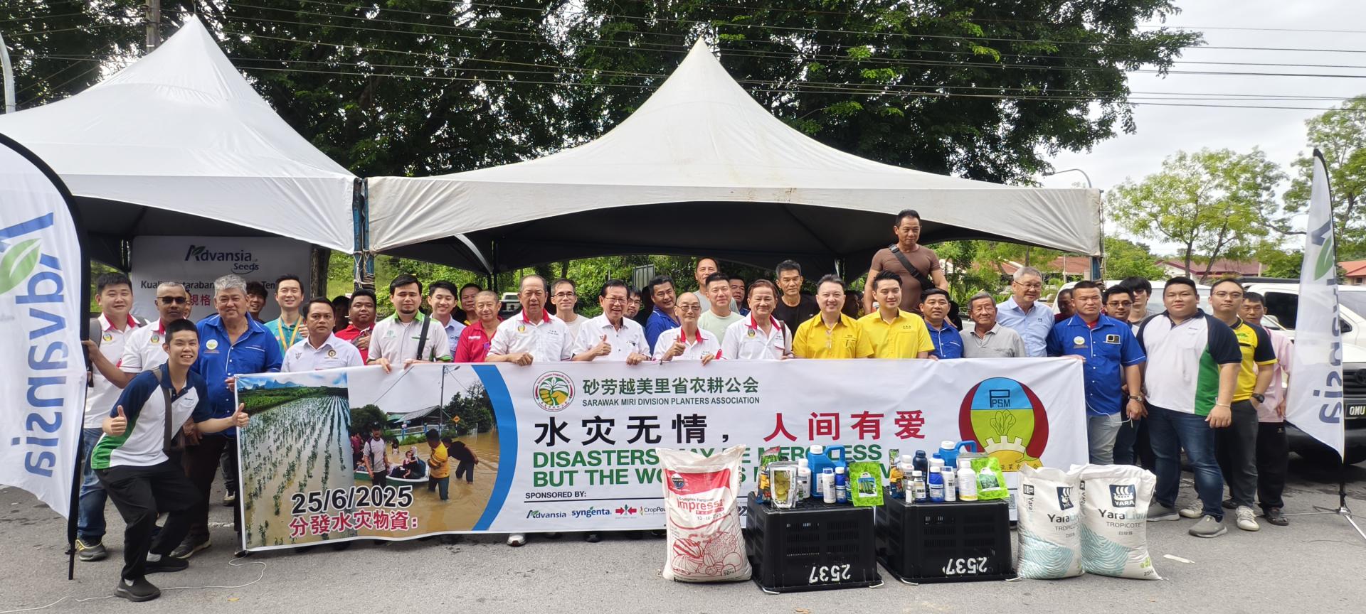 砂劳越美里省农耕公会举行《水灾无情，人间有爱》分发水灾物资仪式合影。中排左7起为马来西亚菜农总会会长林仕伟、拿督斯里李景胜及美里省农耕公会主席陈伟明。