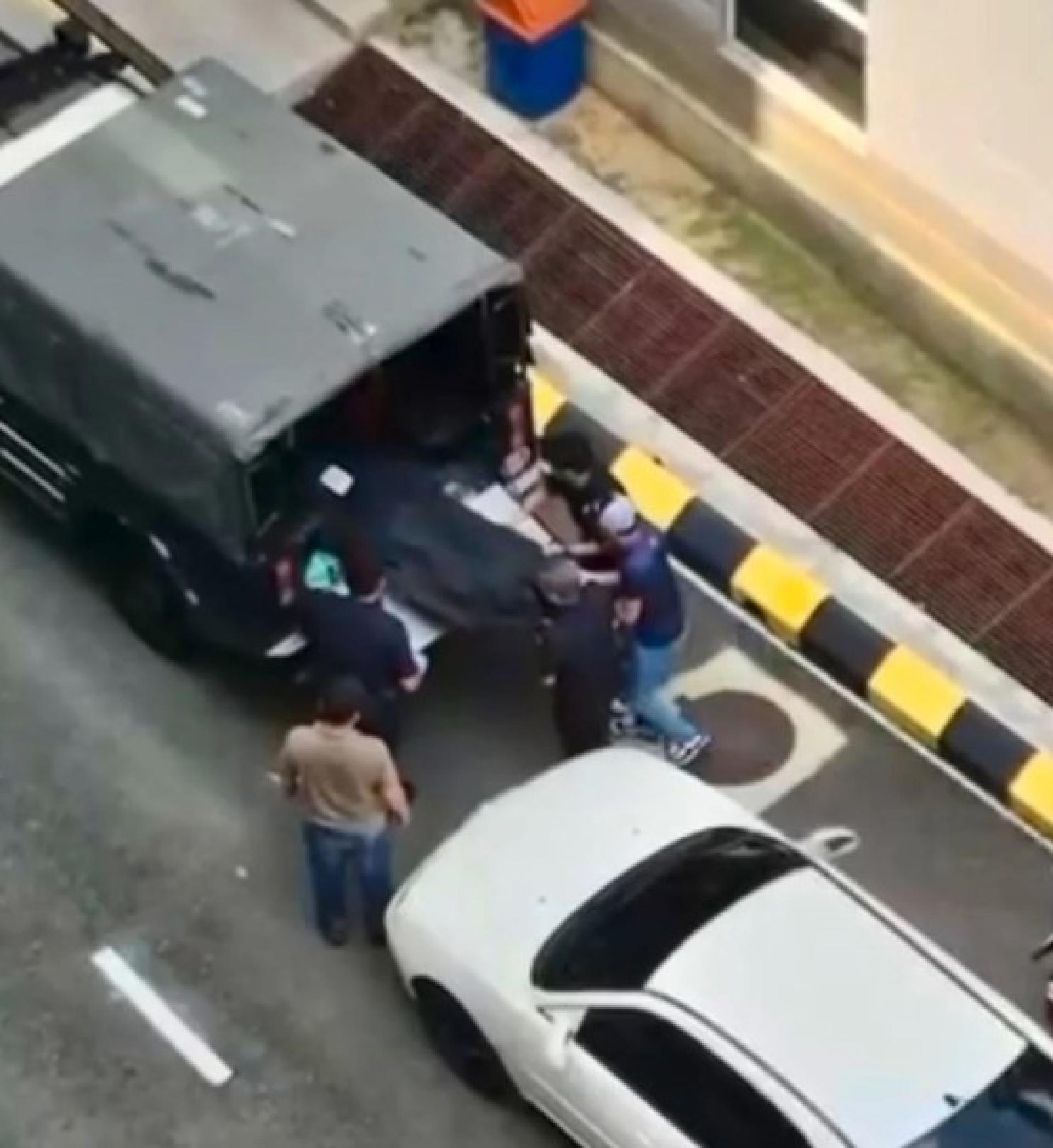 警方将死者遗体抬上警车，准备送往医院。（网络流传视频截图）