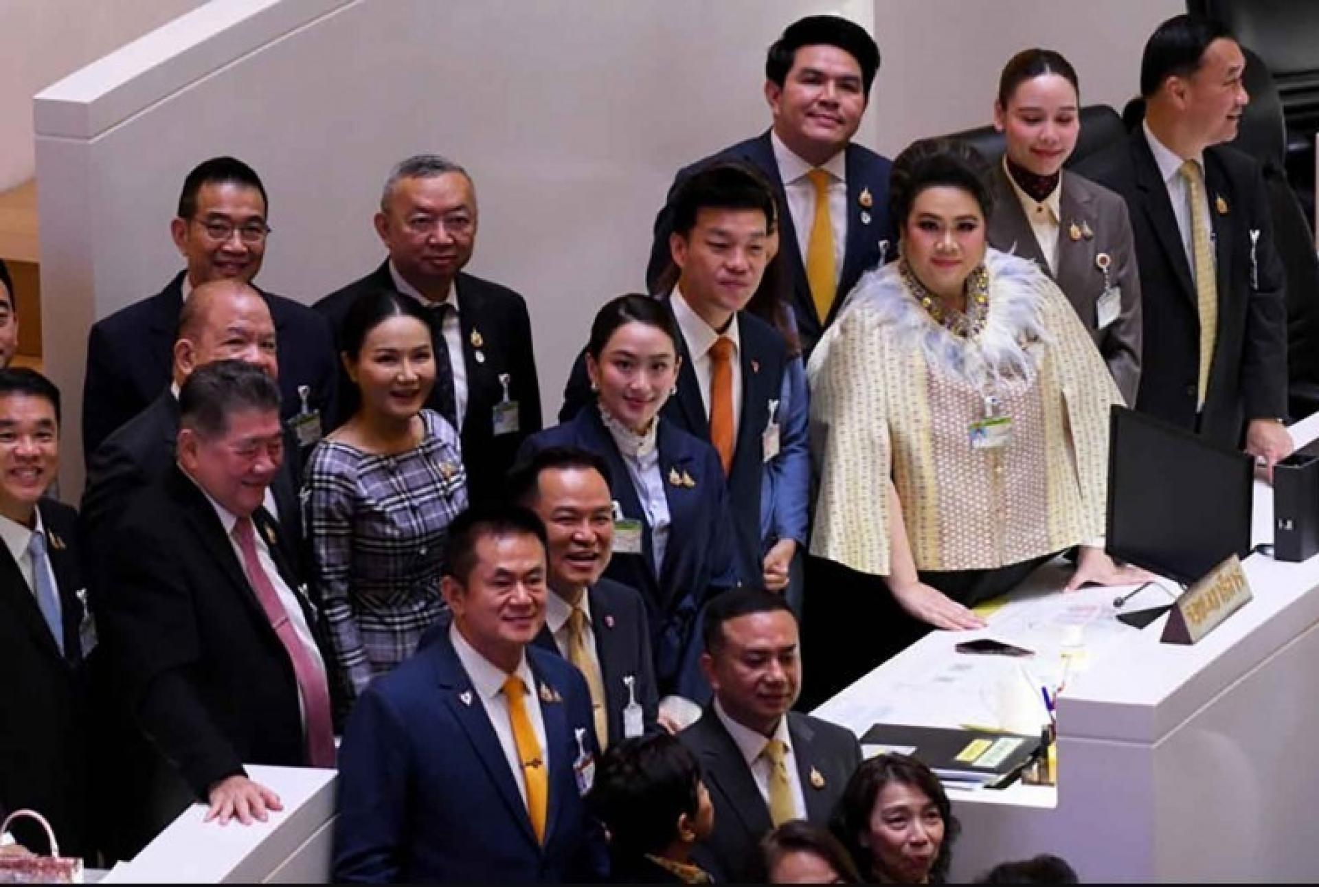 总理佩通坦（中）与反对党领袖纳塔蓬站在一起。今年3月，总理在议会的不信任动议中幸免被弹劾。