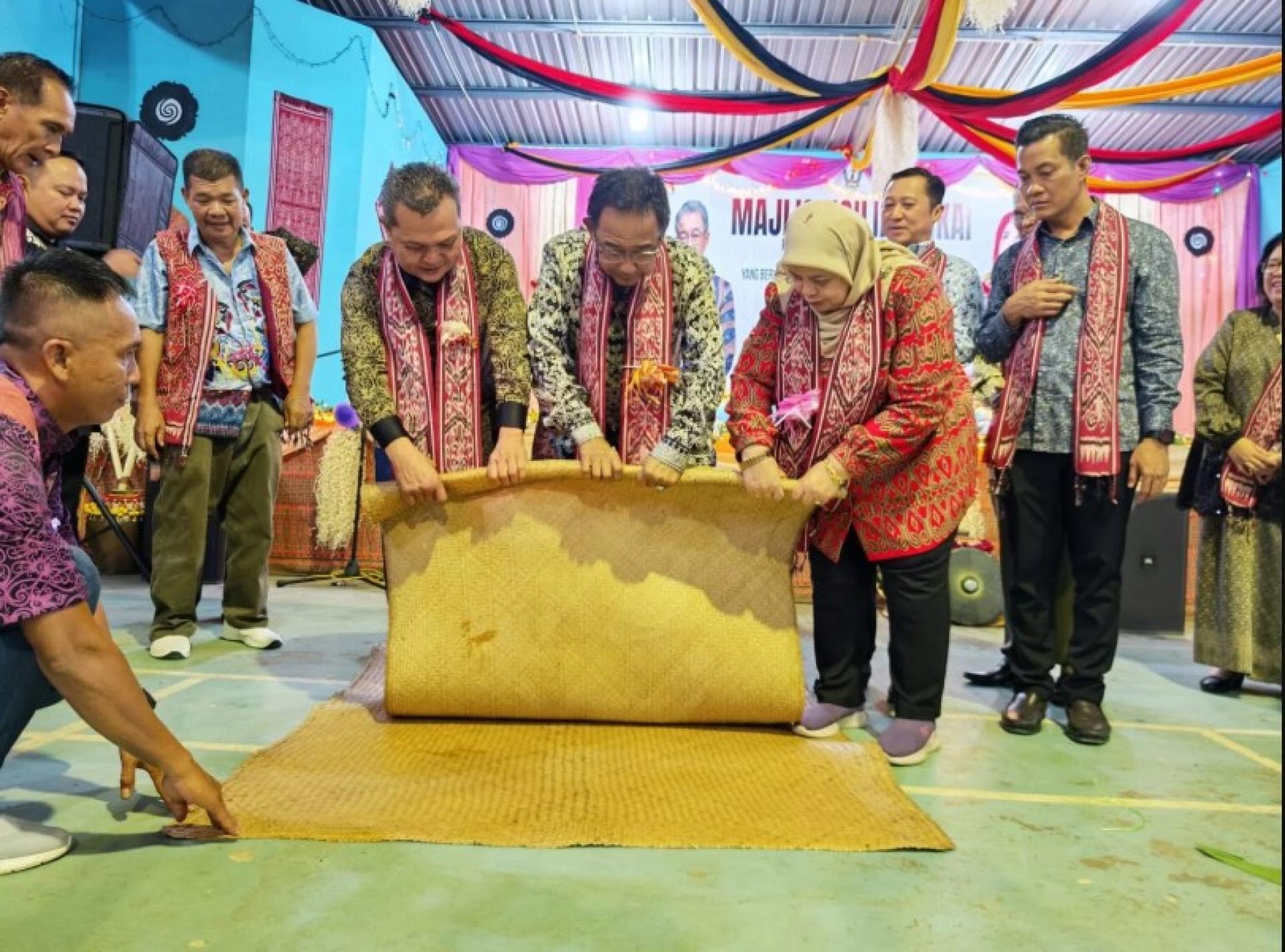 阿都卡林（中）与贵宾一起象征性地进行达雅节卷席仪式。