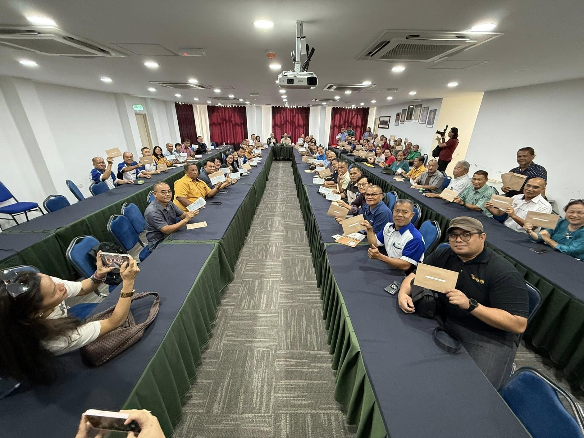 受惠团体展示所获得的拨款支票并与砂拉越交通部副部长（河流及海洋）兼石隆门区立法议员拿督亨利吉纳（中）合影。