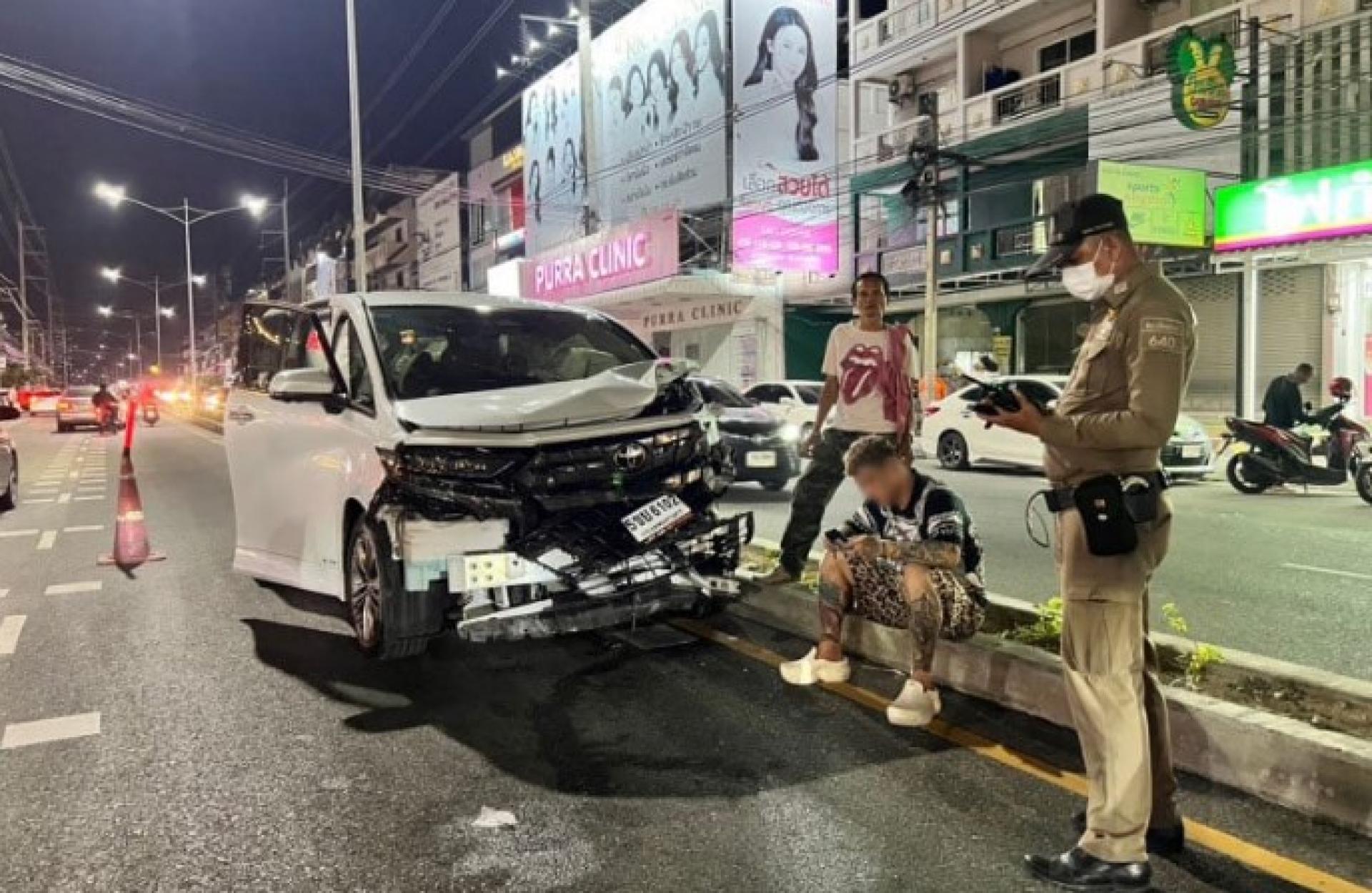 肇事汽车以及被警方扣留的中国男子（坐者）。（图：曼谷邮报邮报）