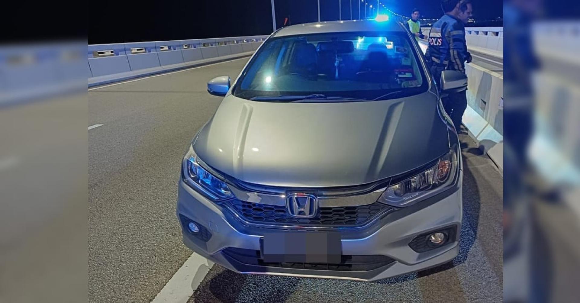 一辆相信是坠海华青驾驶的本田轿车，停泊在槟城二桥上。