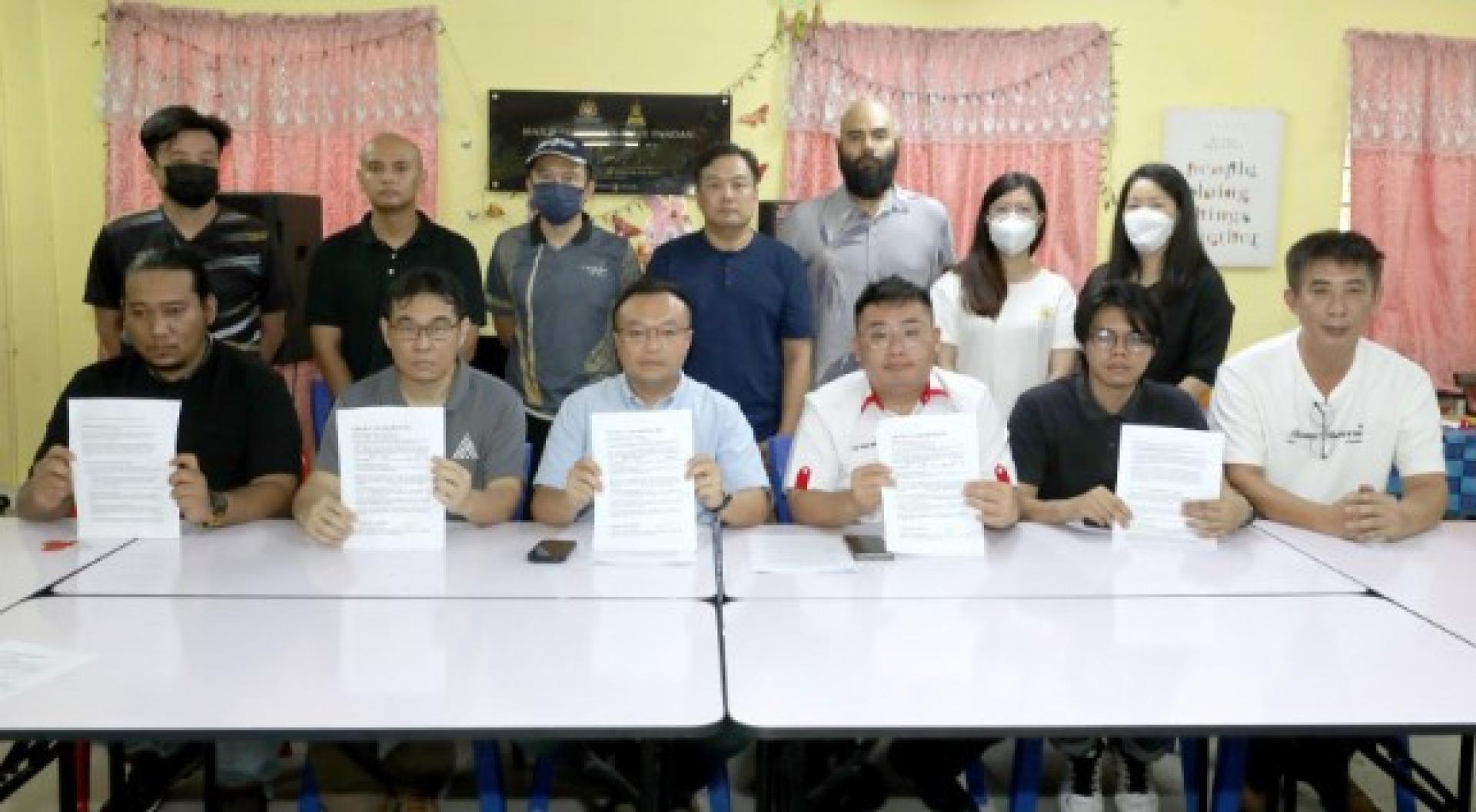 陈健坤（前排左2起）与游佳豪展示卖家的声明文告，呼吁政府纠正电商平台的不公机制。