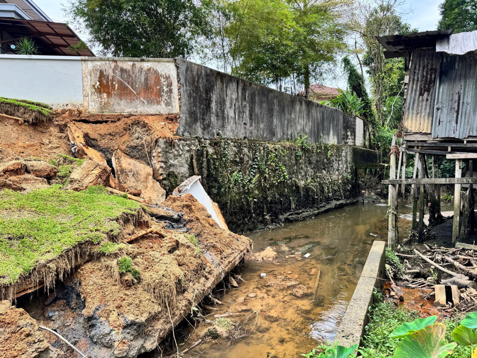 去年发生的土崩事件，导致挡土墙倒塌，并对四户住宅的后院造成破坏。