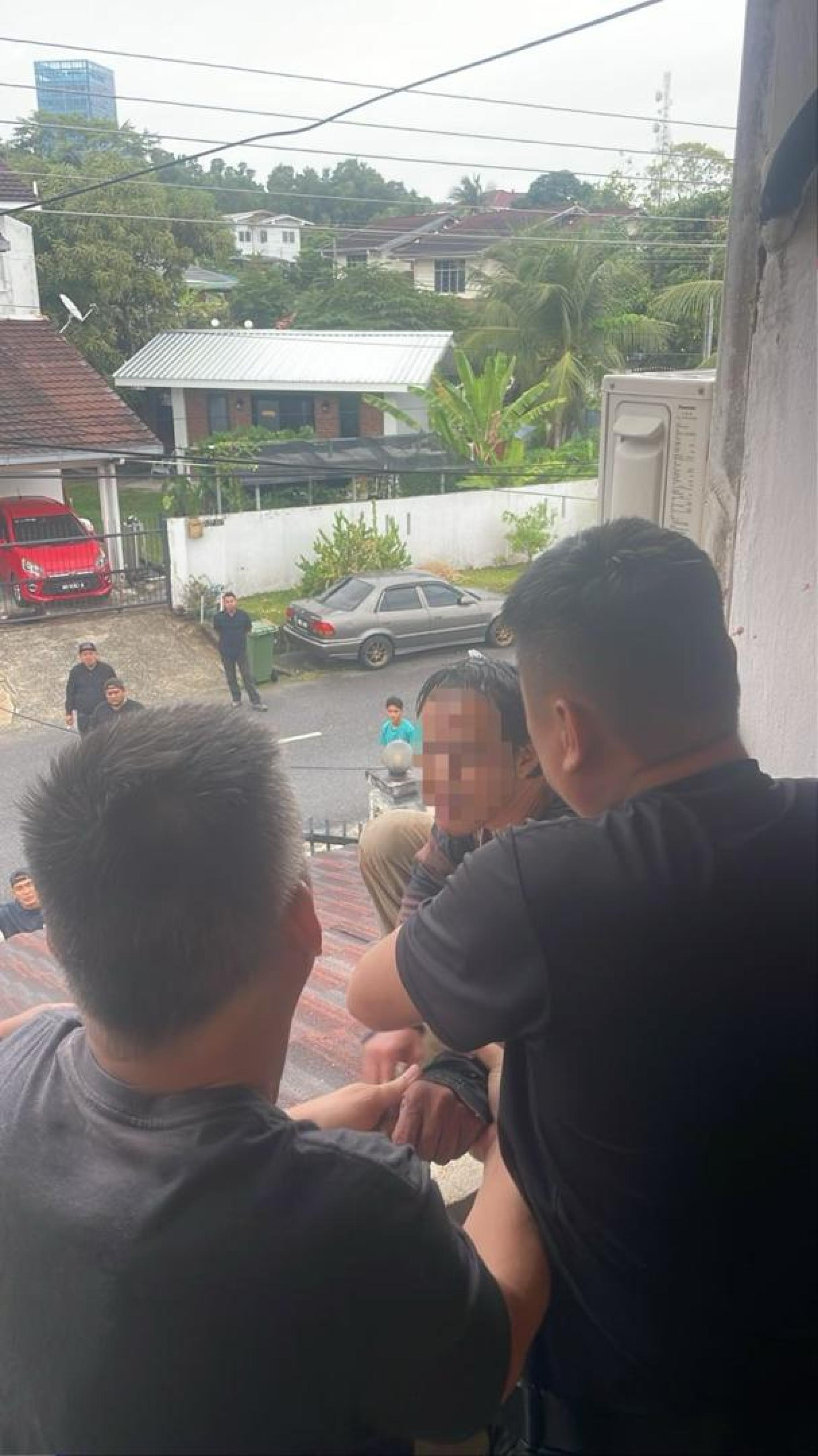 男子持刀闹事爬上屋顶。