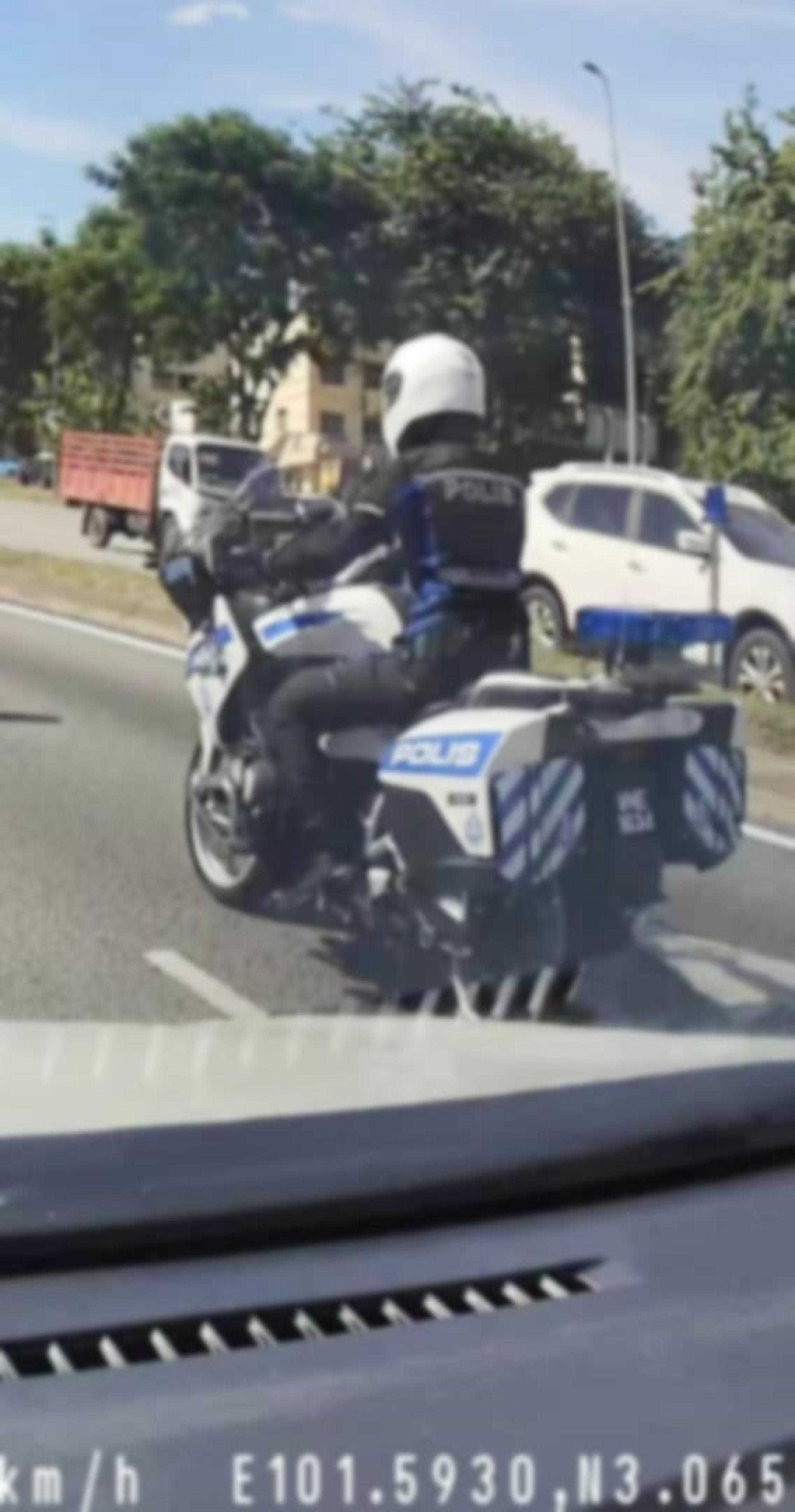 疑似身穿警察制服的警察，骑着印着马来文字眼“警察”的大型摩托车。