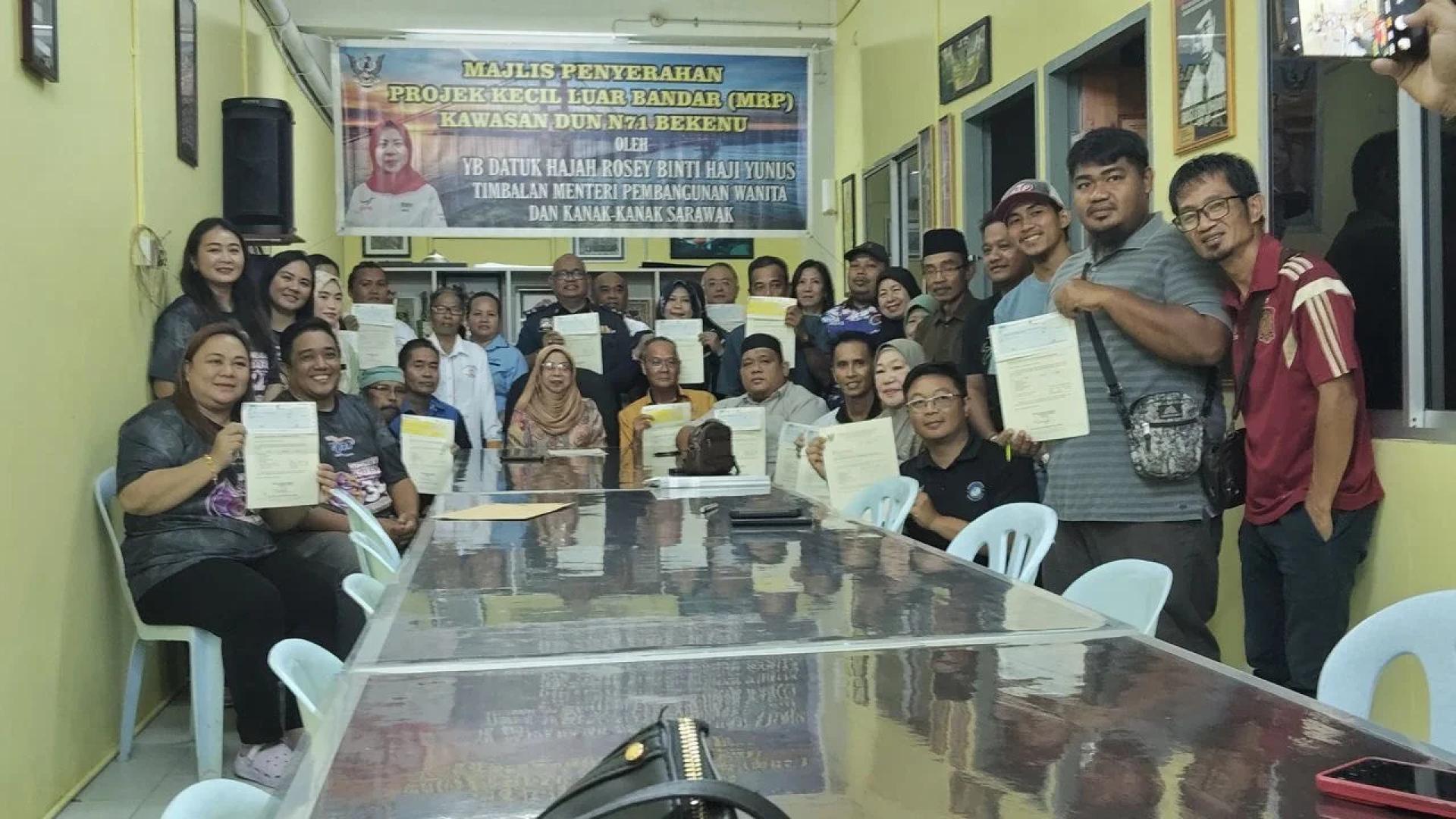 Rosey merakamkan gambar kenangan bersama penerima peruntukan Projek Kecil Luar Bandar (MRP) di Pusat Khidmat Wakil Rakyat, Bekenu hari ini.