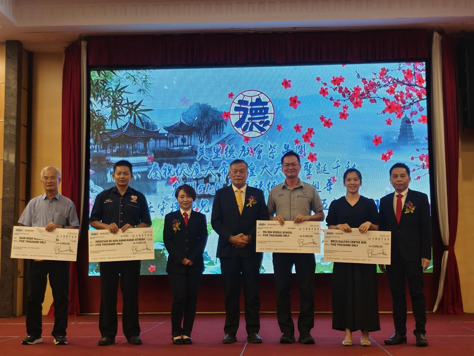 美里德教会紫星阁创阁51周年“五福盛会”联欢晚宴上，移交捐款美里特殊儿中心，美里红星月会洗肾中心，美里培民中学及美里廉律中学代表合影。左3起为筹备会主席吴彗厤、阁长许为隆及署理阁长吴训华（右）。