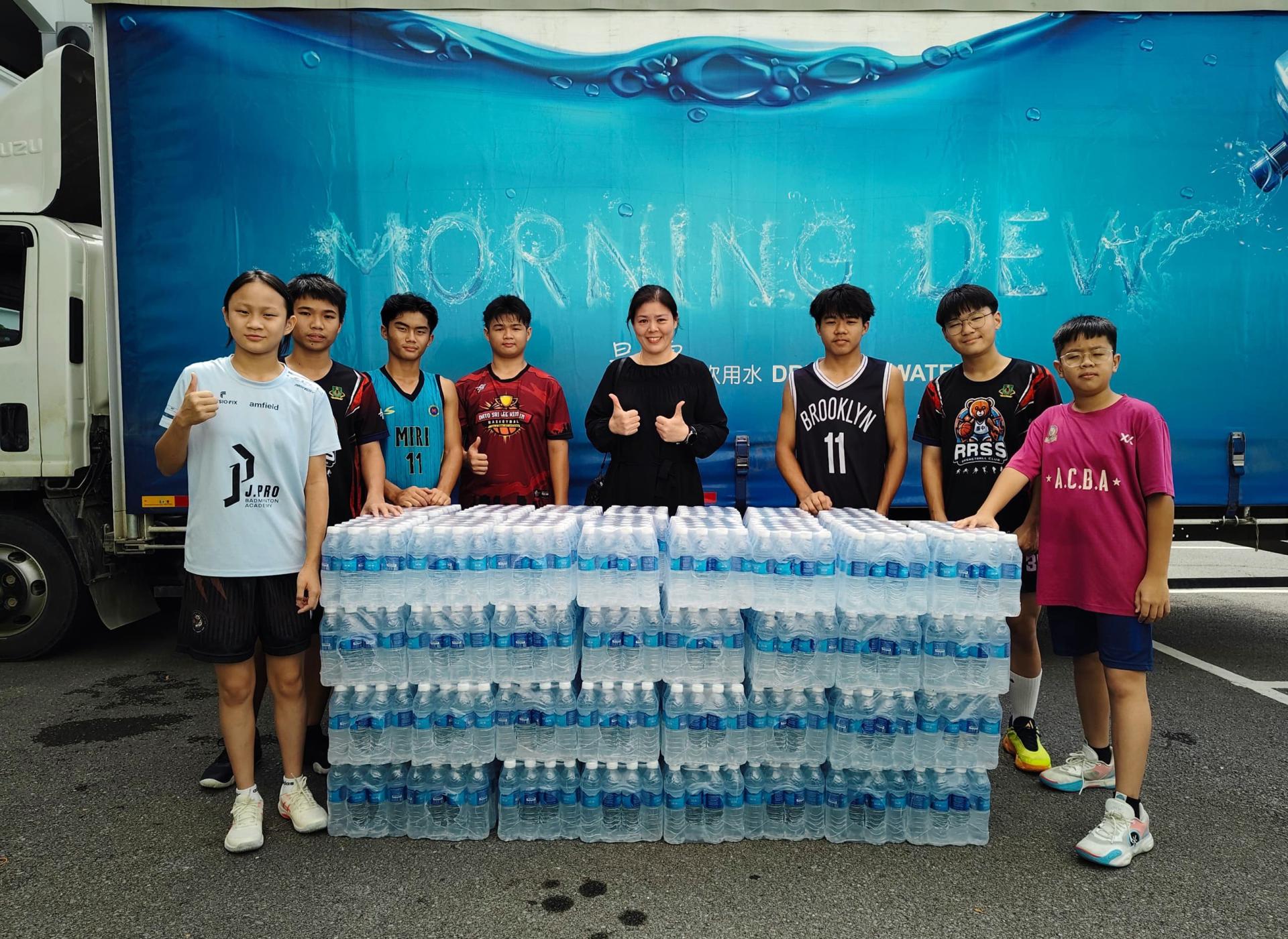 廉律中学校长江佩娟（左5）感谢Morning Dew林如盛大力赞助款泉水供活动使用。