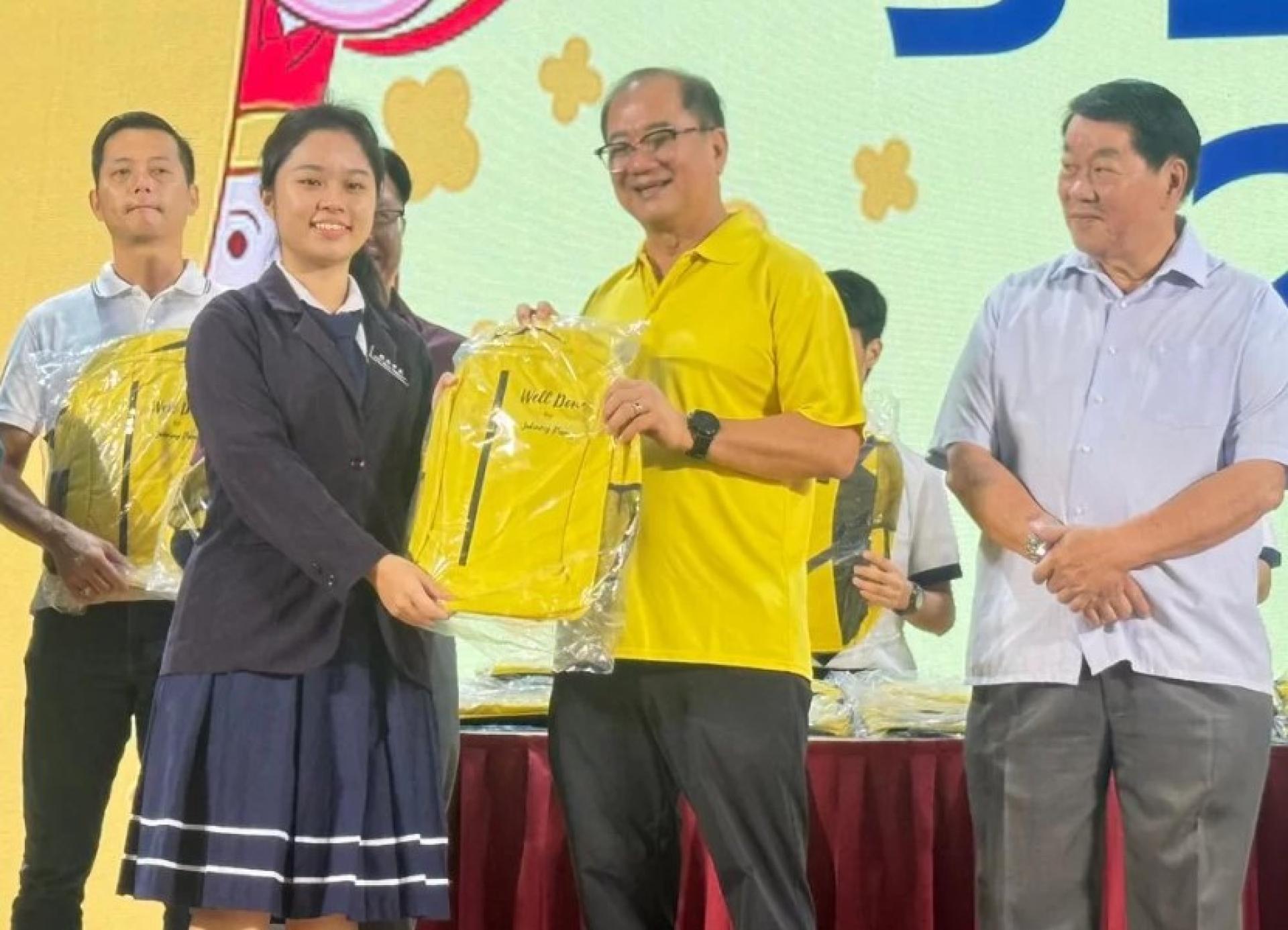 潘隆铭为民都鲁开智中学一名学生移交书包。