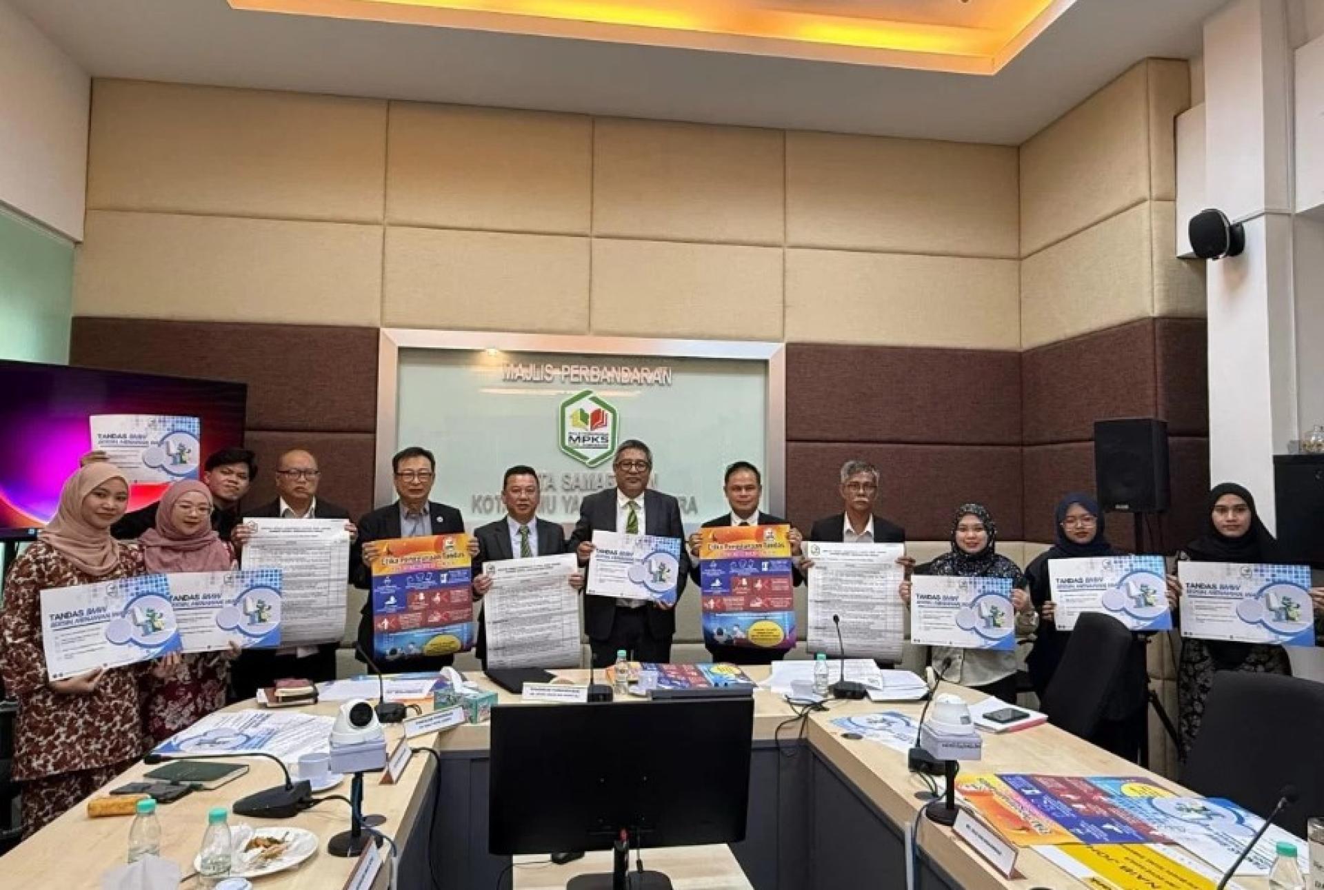阿邦依斯玛威（中）展示“2025年清洁、吸引与芳香（BMW）公共厕所比赛”的宣传海报。