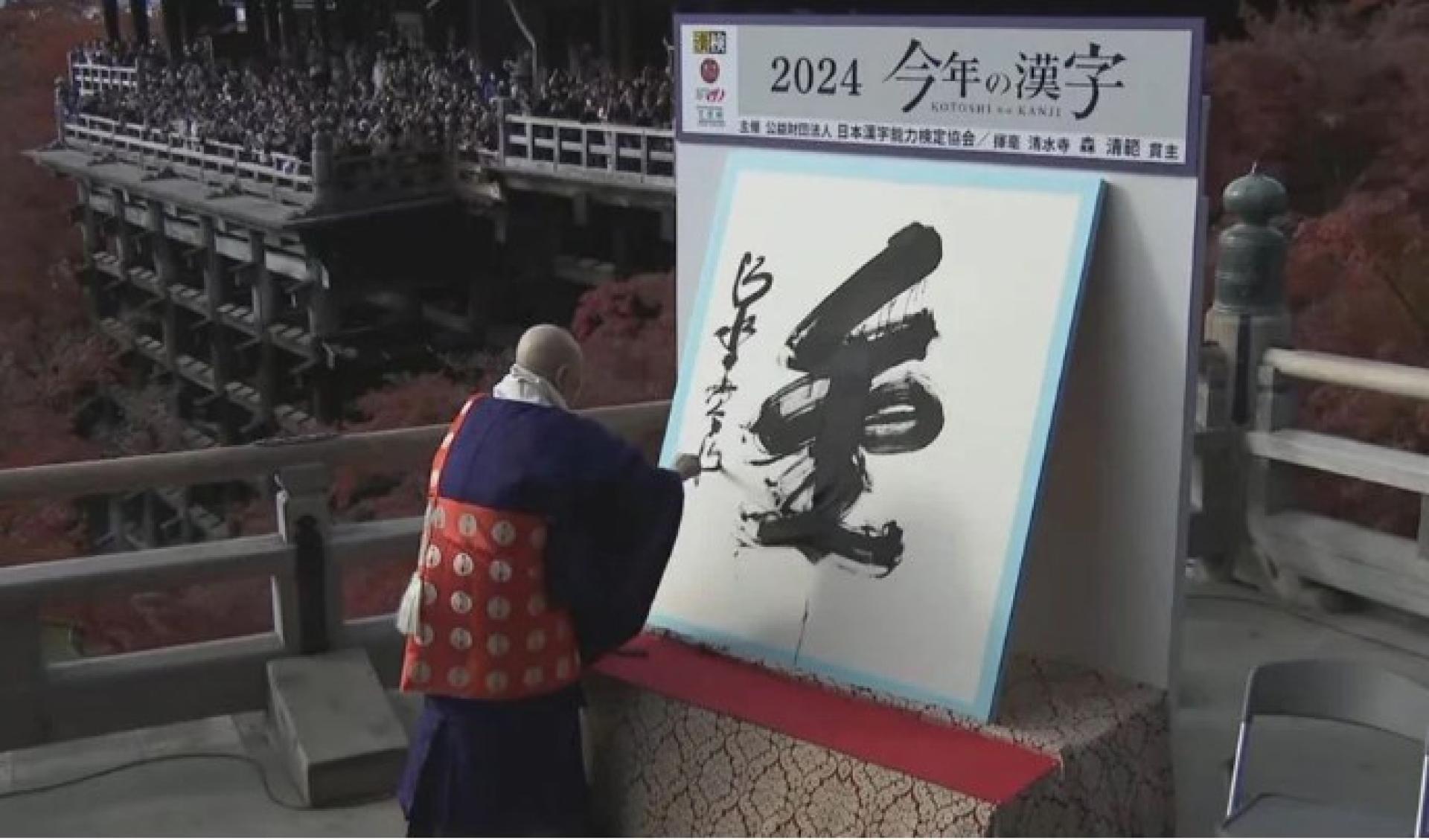 清水寺住持森清范用毛笔在纸上挥毫写就“金”字。
