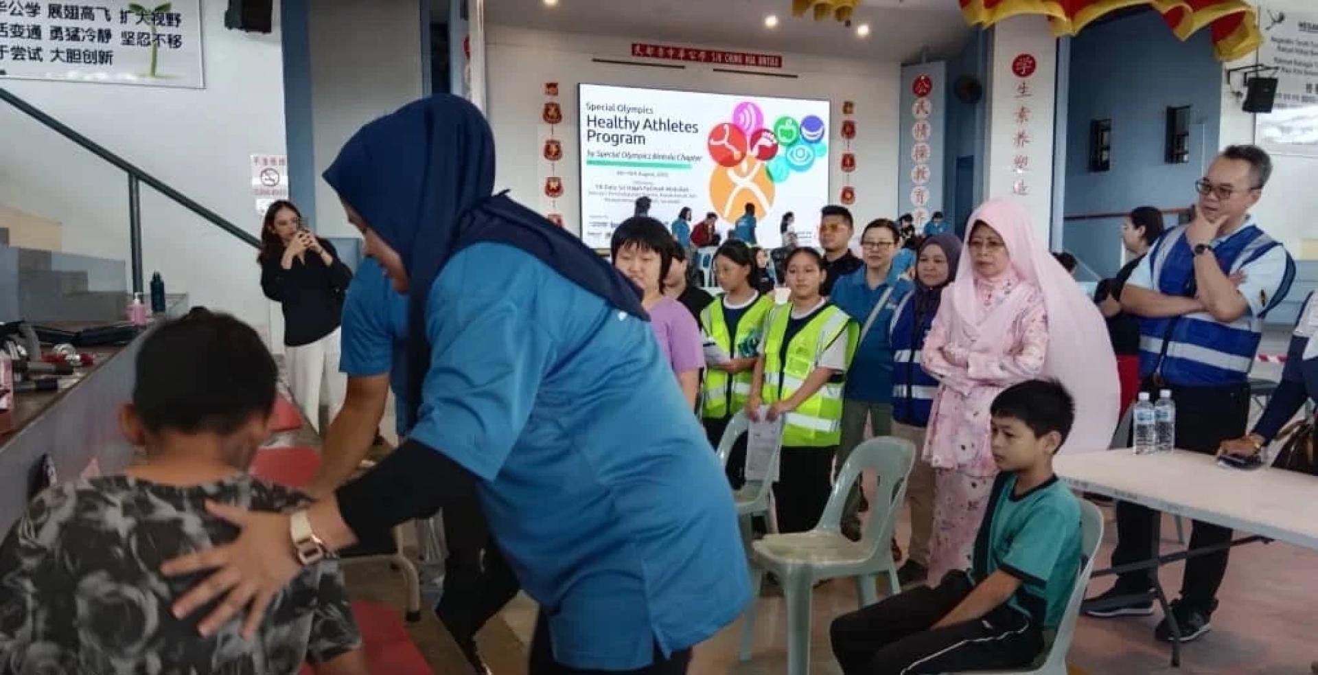 Fatimah ditemani Ruslan meninjau Program Atlet Sihat(HAP) anjuran Special Olympic Bintulu Chapter yang diadakan di SJK Chung Hua Bintulu.