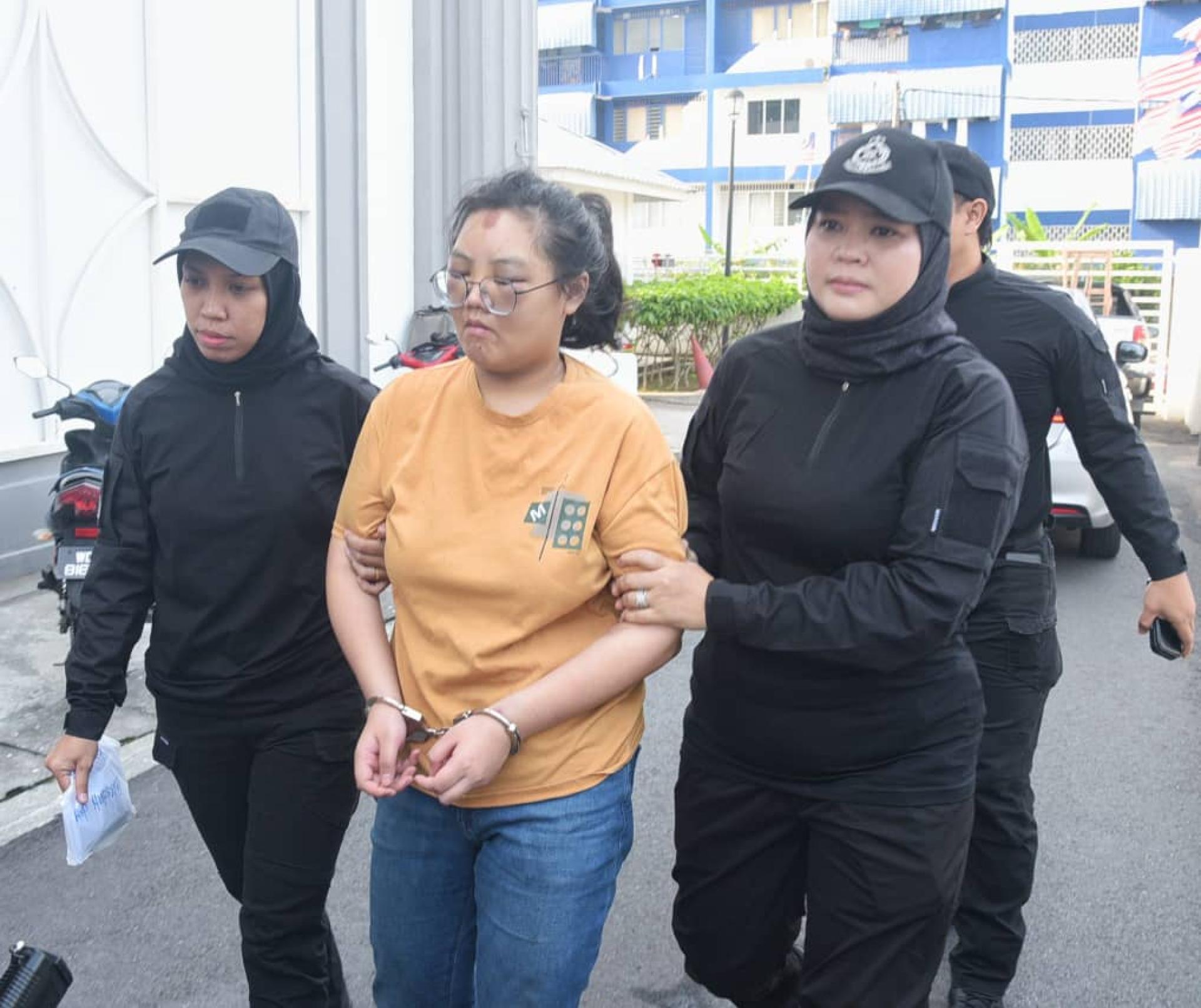 女子被警方押上法庭时，可见双眼及额头有淤青迹象。