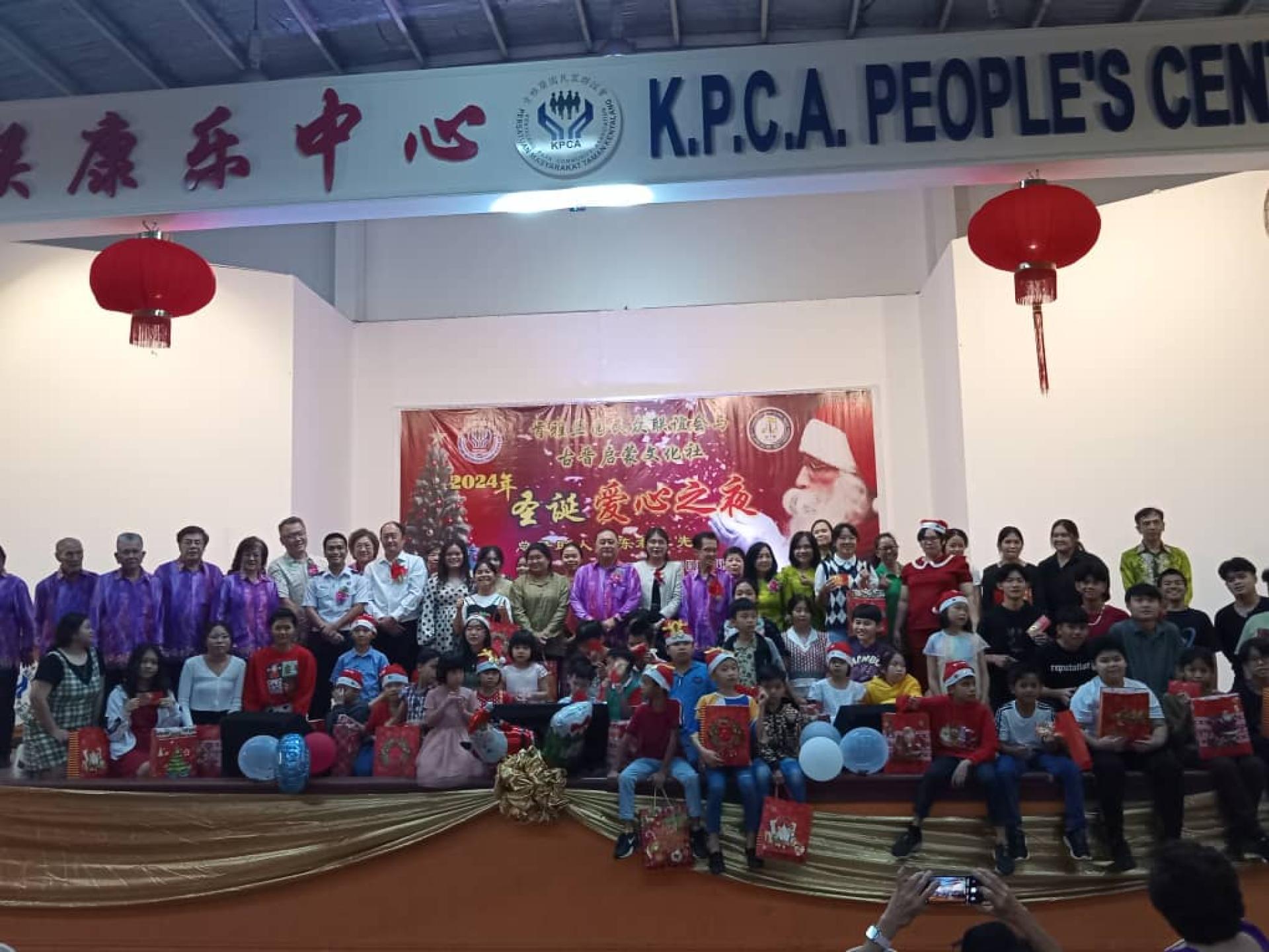 救世军之家的儿童及青少年在2024年圣诞爱心之夜晚宴领取红包和礼品后，与肯雅兰园民众联谊会和古晋启蒙文化社的理事们以及嘉宾们大合照。