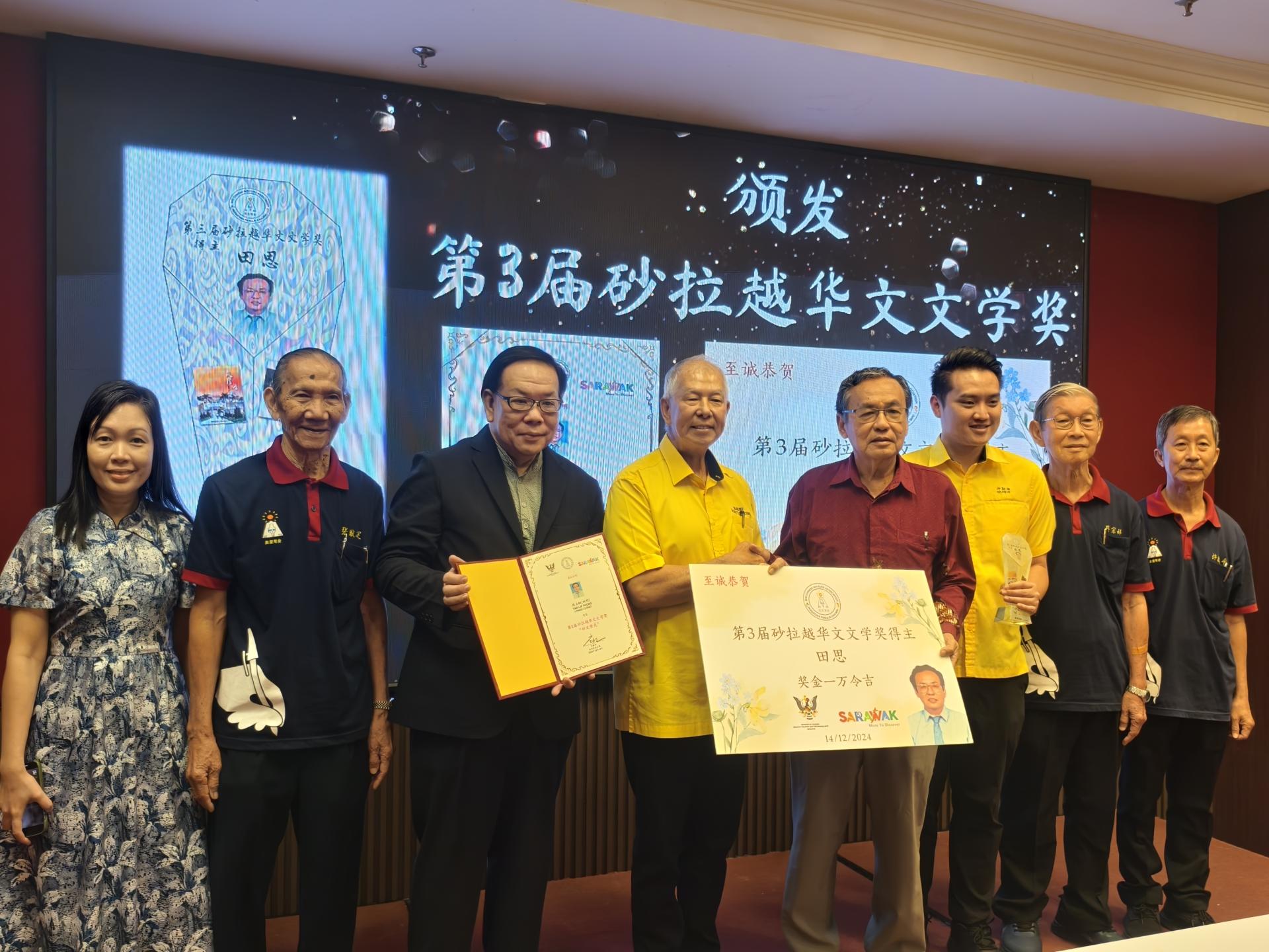 砂拉越旅游部副部长拿督陈超耀（左4）颁发第3届砂拉越华文文学奖给得主田思（右4）。