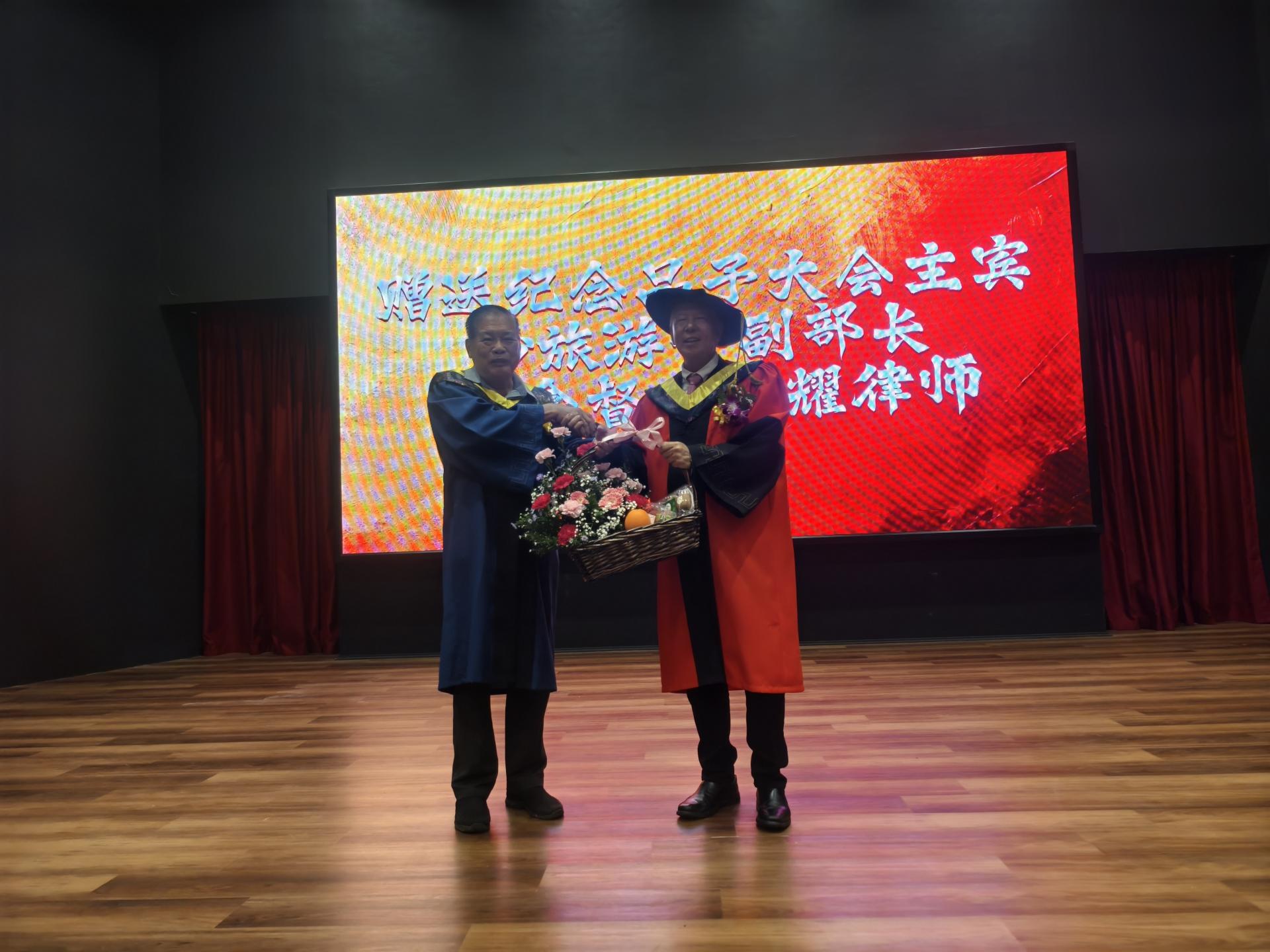 培民中学署理董事长陈则胜（左）赠送水果花篮给大会主宾拿督陈超耀。