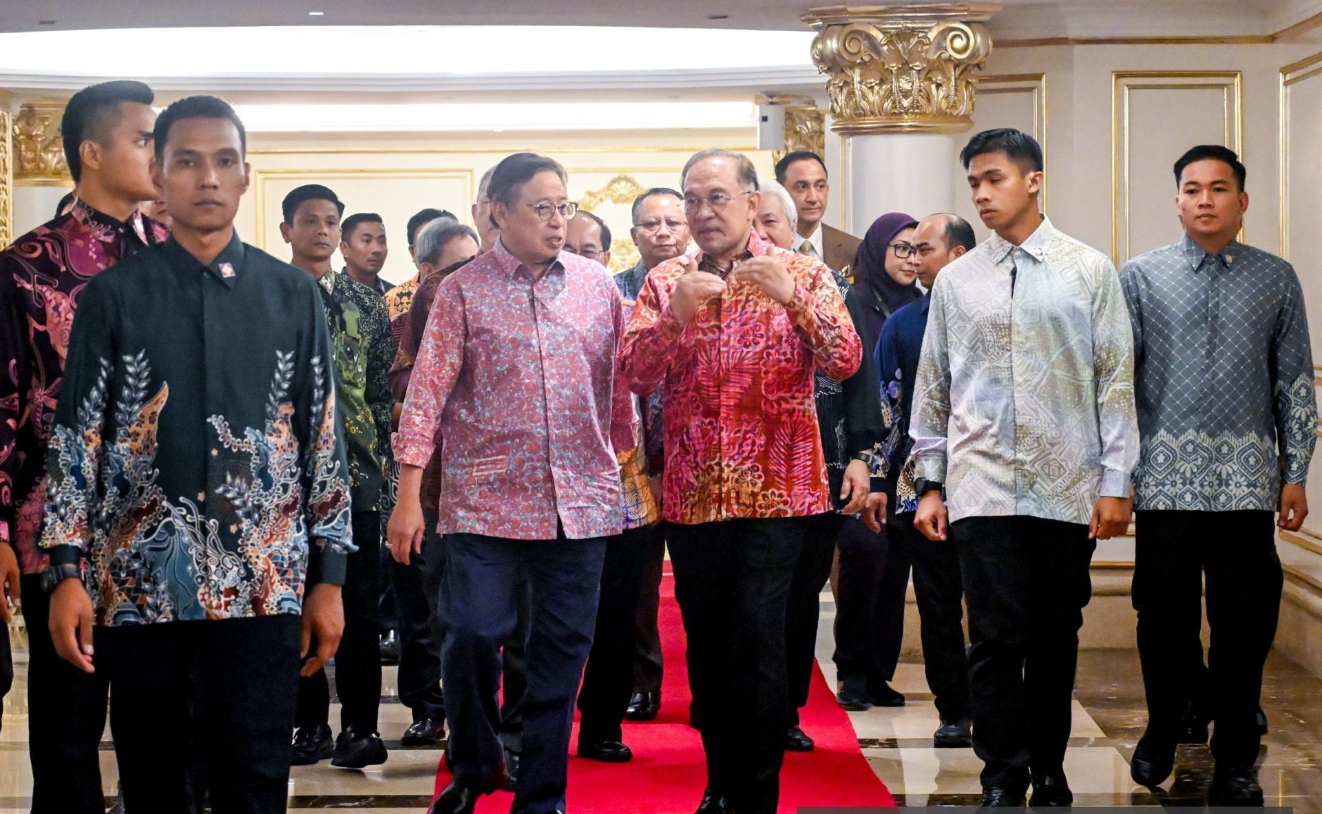 砂总理阿邦佐哈里（左2）和首相安华（右3）边步入晚宴会场时边交流。