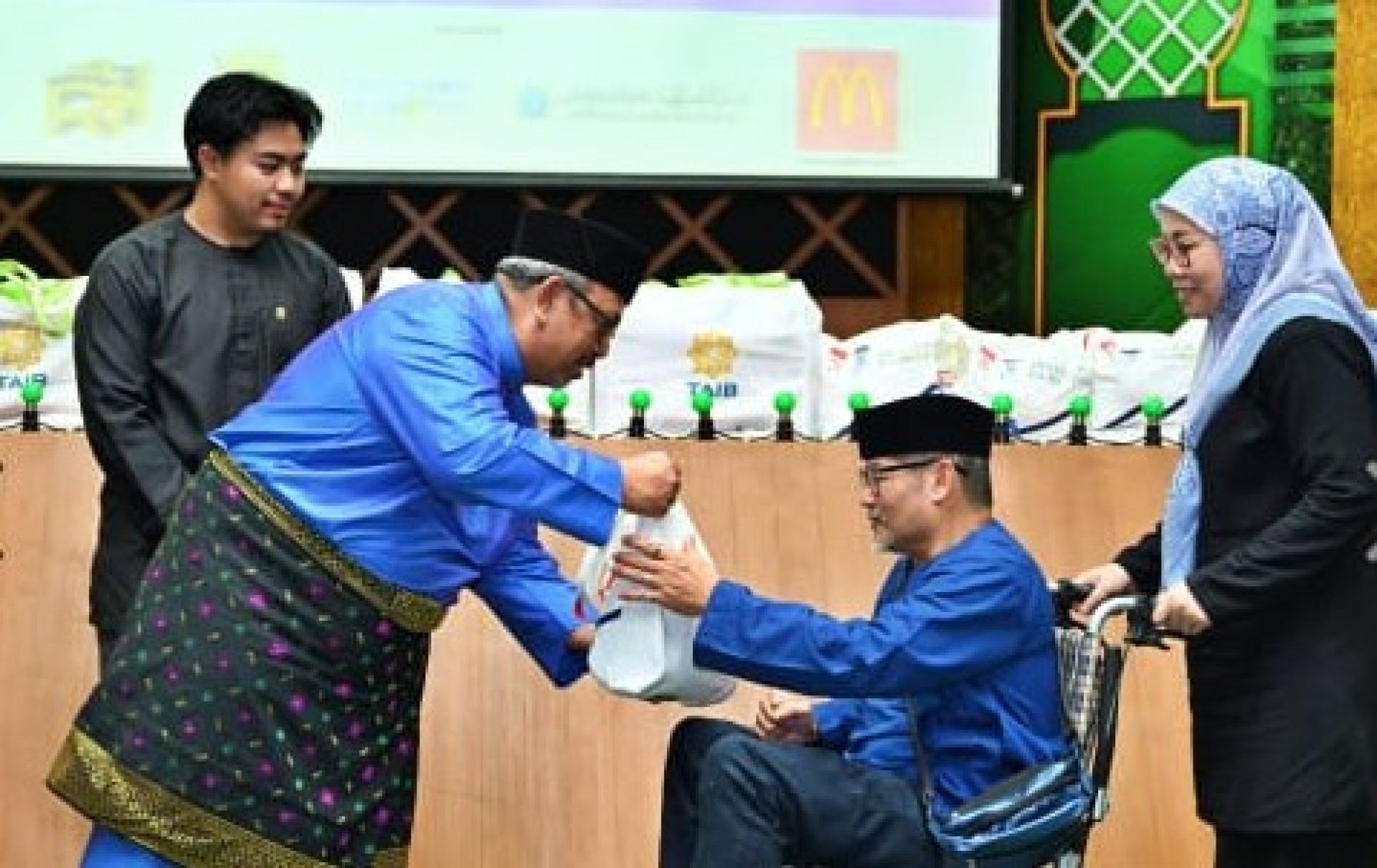 宗教事务部代副常任秘书Haji Ahmad Nizam 移交必需品予受惠者郑天强