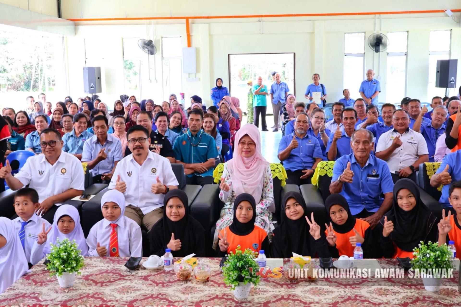 Fatimah (seated, centre) poses for a photo with others.