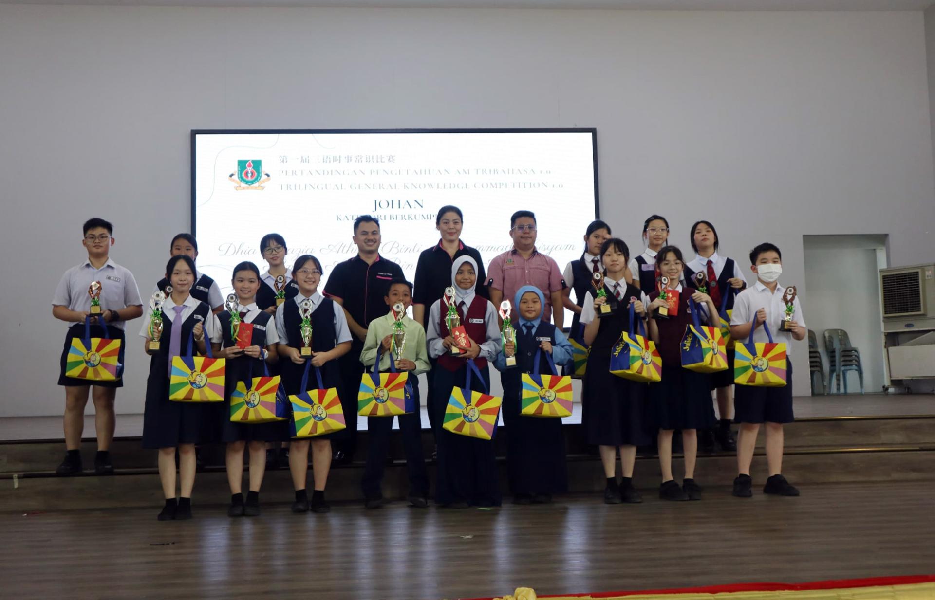 校长江佩娟（后排左5）与得奖的小学团体组合影，由副校长康亚雄（左4）及副筹备会主席赖德文（右4）陪同。