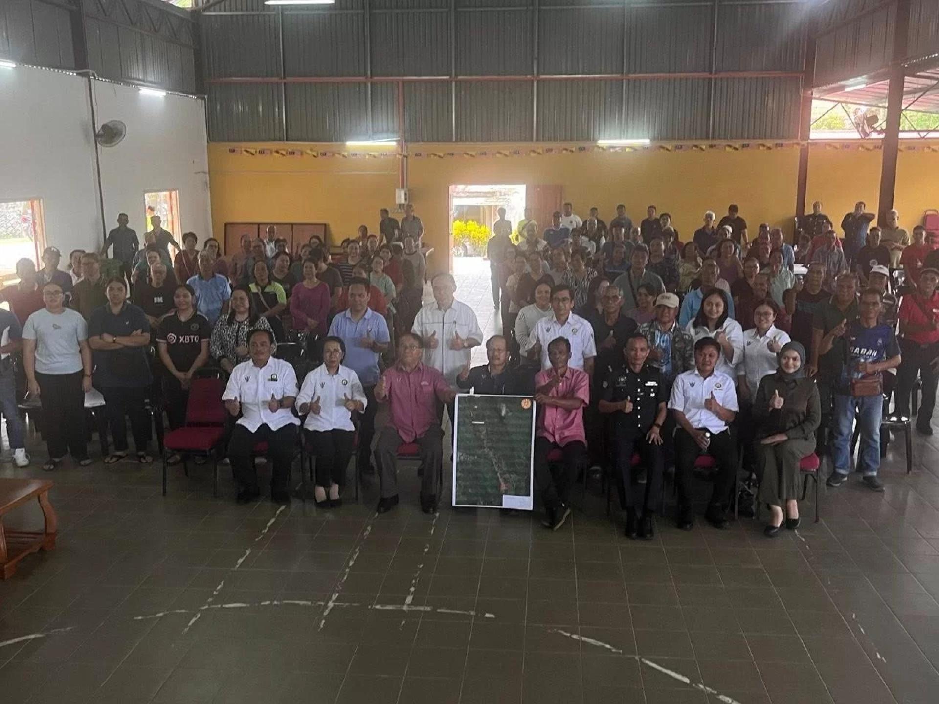 Dr Simon (seated centre) with participants during the dialogue on NCR land survey and issuance of titles at Kampung Jenan. Photo: UKAS